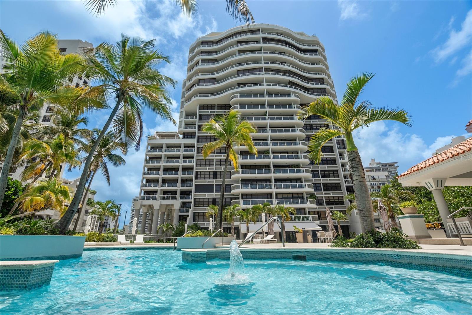 Introducing a rare gem of beachfront luxury living in the heart of Condado. This exquisite sub-penthouse offers the epitome of high-end living, where every detail has been meticulously curated to provide an unparalleled lifestyle reminiscent of a five-star resort. Spanning an impressive 3,727.27 sq. ft., this ultra-luxurious residence boasts 4 bedrooms (+ Maid’s Room) and 4.5 bathrooms, ensuring ample space for both relaxation and entertainment. As you step into the elegant interior, you'll be greeted by the opulence of chandeliers gracing every corner, casting a soft, enchanting glow. The expansive wrap-around balcony, accessible from the kitchen, living room, dining room, and the master bedroom, evokes the sensation of being aboard a luxurious cruise ship, with panoramic ocean views that span the azure coastline.
This property is more than just a home; it's a lifestyle. Imagine waking up to the amazing views of the ocean and strolling to nearby restaurants, boutiques, and hotels. The property's amenities are nothing short of extraordinary. The pool area transports you to a realm of leisure, reminiscent of a high-end hotel experience. Direct beach access is another plus. Lounge by the poolside, barbecue in the gazebo, let the little ones play in their dedicated area or enjoy the beach! Puerto Rico living at its finest! For those with an active lifestyle, the gym offers state-of-the-art equipment, and within its walls, you'll discover a haven of wellness. Pamper yourself in the massage room, or experience the rejuvenating effects of the sauna and steam room, allowing you to indulge in relaxation without leaving the comfort of your sanctuary. Safety and convenience are paramount in this exclusive residence. Enjoy the peace of mind that comes with 24/7 security and a dedicated concierge service, ensuring that every need is met with the utmost care and attention.
