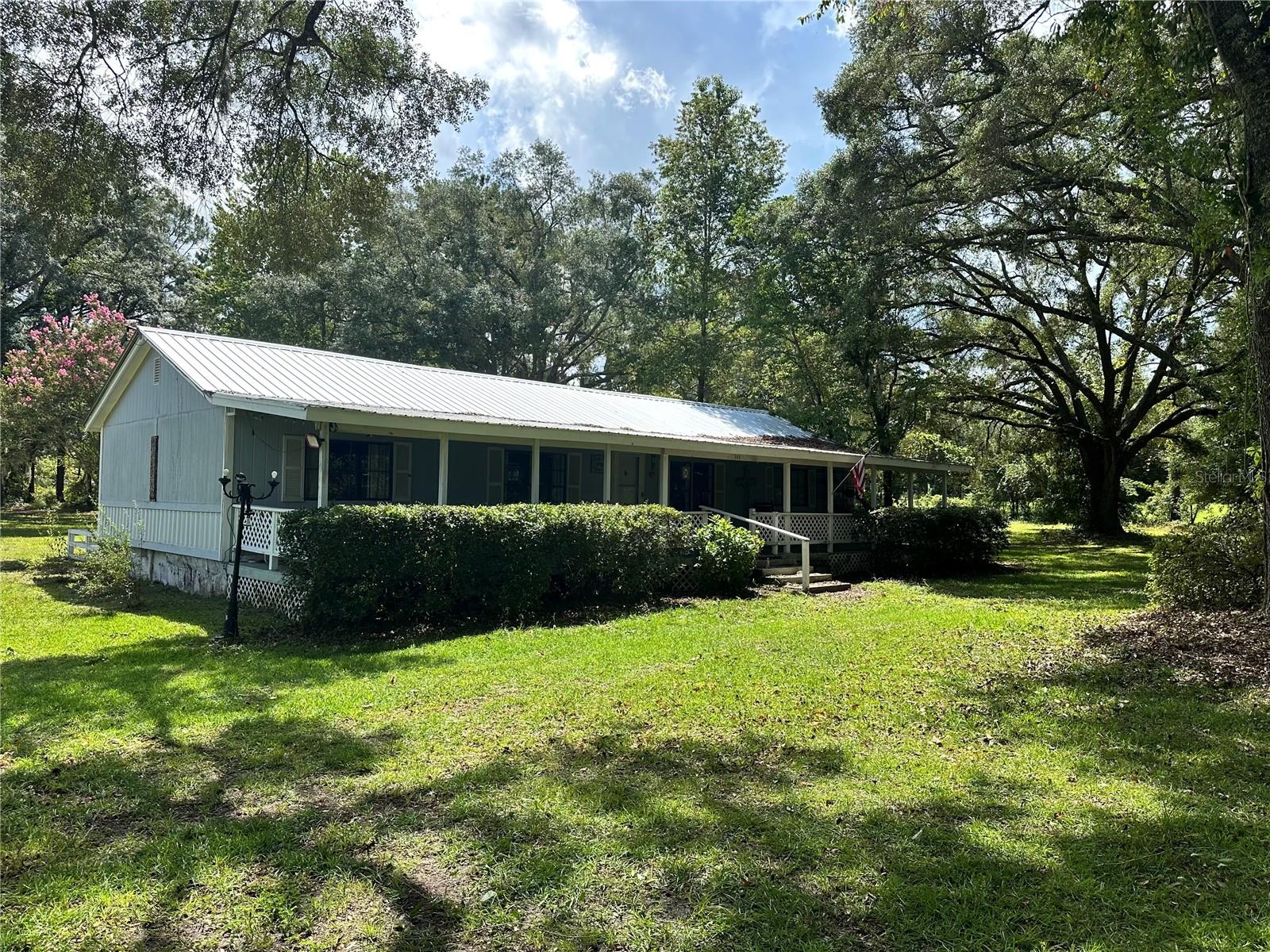 Escape the hustle and bustle of the fast life! The OUTSKIRTS OF TOWN is calling! Down this private / one way in & one way out road you'll see your CHARMING FARMETTE positioned perfectly on the 2.54 acre parcel ADORNED with MAJESTIC MOSSY OAK TREES and mature landscape. This country home is ready for you to add personal touches and make it your own! Rarely available COLUMBIA CITY GEM sits between County Road 240 and Old Wire! Hard to find homes in this area under $500k! Excellent schools all around! X flood zone! Bring your farm animals and get a tax discount! Zoned AG! There is a 30x30 concrete pad shed/shop with electrical in need of some TLC but on its way to being an amazing workshop/garage. A third out building houses the well and has a lean-too. Plenty of Space to park your boat and RV! As you enter the 8ft wide front porch that runs the length of the home, you will be dazzled with the view of the mature live oaks in the front yard. There is ample space for the whole family inside. The back bonus room is perfect for a 4th bedroom or second living room. Cozy master bedroom comes complete with a walk in closet and en suite bathroom with an antique clawfoot tub where you can soak in spring water! There are tongue and groove accents to most of the ceilings in the home to add to the unique charm. THE STARS SURE DO SHINE DIFFERENTLY IN THE COUNTRY! Do not hesitate to seize this opportunity to own real estate close to THE SPRINGS, Ichetucknee River, State Parks all this within minutes of I75 and historic DOWNTOWN LAKE CITY!
