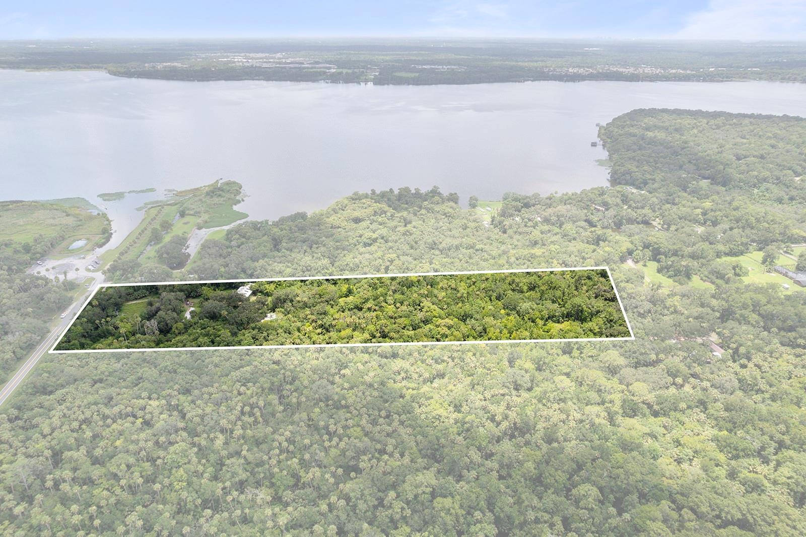 This property offers 9.31 acres of land just minutes from Lake Jesup, strategically located in the fast-growing Sanford/Lake Mary corridor. Situated at 5950 S Sanford Ave, it presents a rare opportunity for investment or development in one of Central Florida's most active submarkets. The property is zoned A-1, allowing for agricultural use, single-family homes, and duplexes (and possibly more). According to zoning officials, there are currently no use restrictions.
The land includes a barn and a mobile home, which remains on-site but is not included in the valuation due to its current condition. With a mix of cleared areas and mature trees, the landscape is versatile and well-suited for various uses.