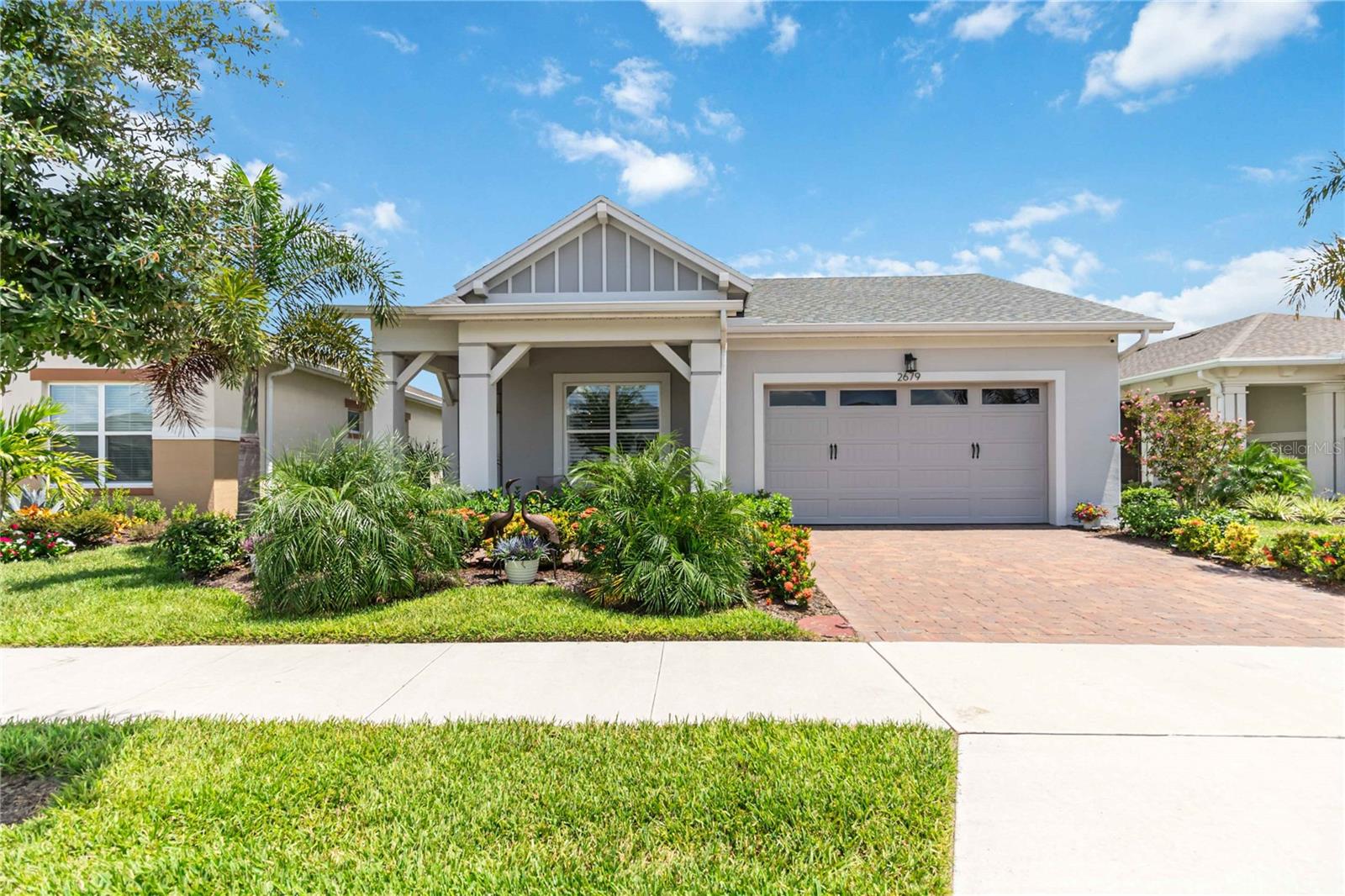 Welcome to your dream home in the serene Del Webb Twin Lakes community of St. Cloud, Florida! This exquisite luxury property features an open floor plan that offers a perfect blend of comfort and elegance, situated in a vibrant 55+ community designed for a relaxed lifestyle. Step inside from the custom glass door discover tray ceiling foyer, plank flooring, crown molding and plantation shutters throughout the entire home. Whole house generator installed 2024. All doors are 2 panel square 8' doors upgraded from arched. The heart of the home is the stunning modern gourmet chef's kitchen with 5 burner gas cooktop, built-in upgraded oven & microwave, upgraded 3 tier dishwasher, polished chrome handles and pull out shelves, 42" cabinets with stacked cabinet uppers with seeded glass and low voltage lighting subway porcelain tile backsplash, under cabinet lighting, large sink, quartz island that invites gatherings and culinary creativity. Plus, the home comes with perfect lights and ceiling fans allowing you to create the perfect ambiance. Living room features the custom built-in entertainment wall, shelving and storage. Outside, unwind in your private pool oasis, with the spa that backs to the pond surrounded by palm trees and professionally landscaped yard perfect for soaking up the Florida sun or enjoying peaceful evenings under the stars. Primary suite boast custom professional paint accent walls, tray ceiling with lightning, and great view of the scenic outside living. Primary bathroom features custom tile to ceiling, in shower plus tile on accent wall with custom mirrors. Walk-in closet with tons of custom shelving and storage to ceiling. Need a in-law suite, 2nd Bedroom could be used for a second primary bedroom. Professionally built-in office in the Office area off of the Kitchen. Garage has tons of shelving for storage as well. Whole house water filtration system. Twin Lakes boasts exceptional amenities, including multiple pools, a state-of-the-art gym, and a luxurious clubhouse that hosts a variety of community events. Don't miss out, call today for your private tour.