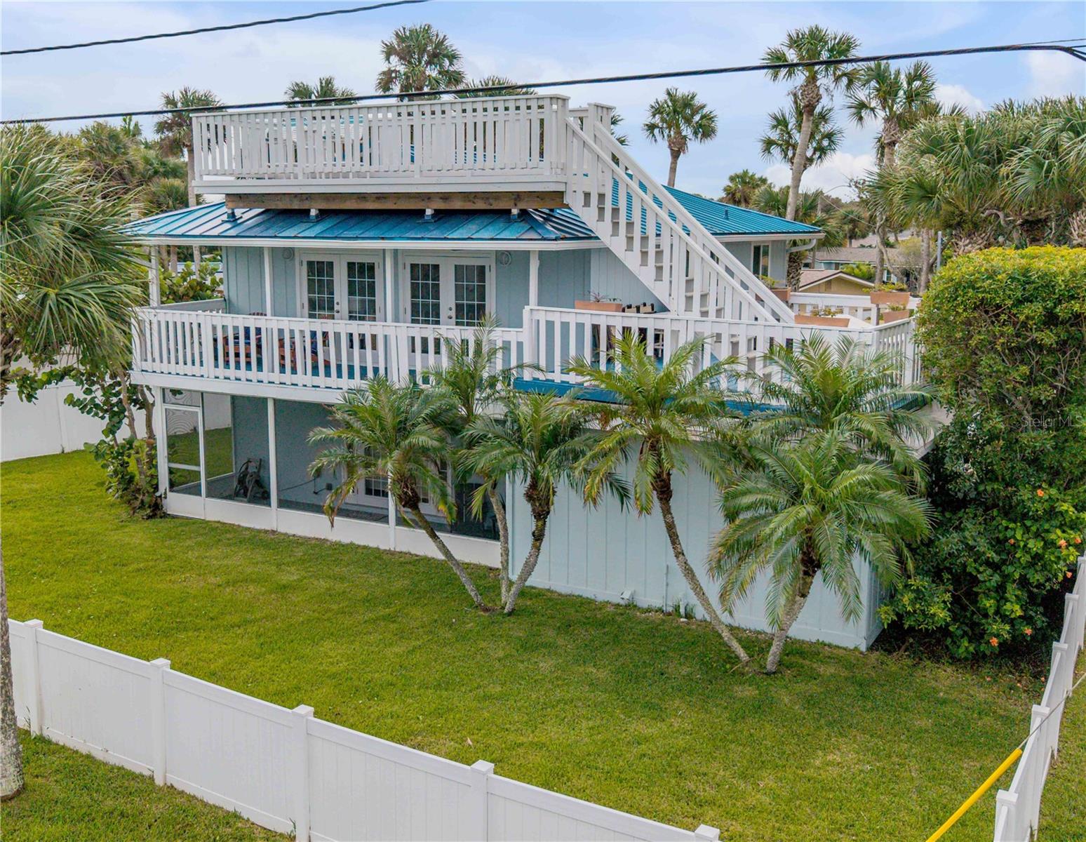 Coastal Charm Meets Modern Comfort! This beautifully updated beachside home blends classic character with modern upgrades, offering the perfect balance of indoor comfort and outdoor living. Situated on a desirable corner lot just moments from the ocean, you’ll enjoy sea breezes, sunny decks, and a private backyard oasis. Relax and entertain around the heated gas pool and spa, surrounded by a fully fenced yard.  French doors open to a charming side yard, creating a seamless flow between indoor and outdoor spaces. Inside, the first-floor primary suite features a remodeled ensuite bath with a tiled shower and Jacuzzi tub, along with a bonus bedroom and half bath on the main level. The upstairs living area is light and welcoming, with hardwood floors, a wood-burning fireplace, and built-in shelving for style and storage. The kitchen shines with granite countertops, bead-board cabinetry, a tile backsplash, and stainless steel appliances. Step through double French doors to enjoy morning coffee on the east-facing porch or dine outside on the 22' x 17' Trex deck—perfect for evening meals and ocean breezes. A widow’s walk offers panoramic views, adding to the coastal charm. Additional upgrades include hurricane-rated windows (2015), and a mini-split HVAC unit for energy-efficient comfort. Oversized 1 car garage plus an outdoor shed will store all your beach toys. Hop in your golf cart and enjoy all of NSB's favorite restaurants or bike over to Flagler Ave.   This home captures the essence of New Smyrna Beach living—relaxed, refined, and ready to enjoy.