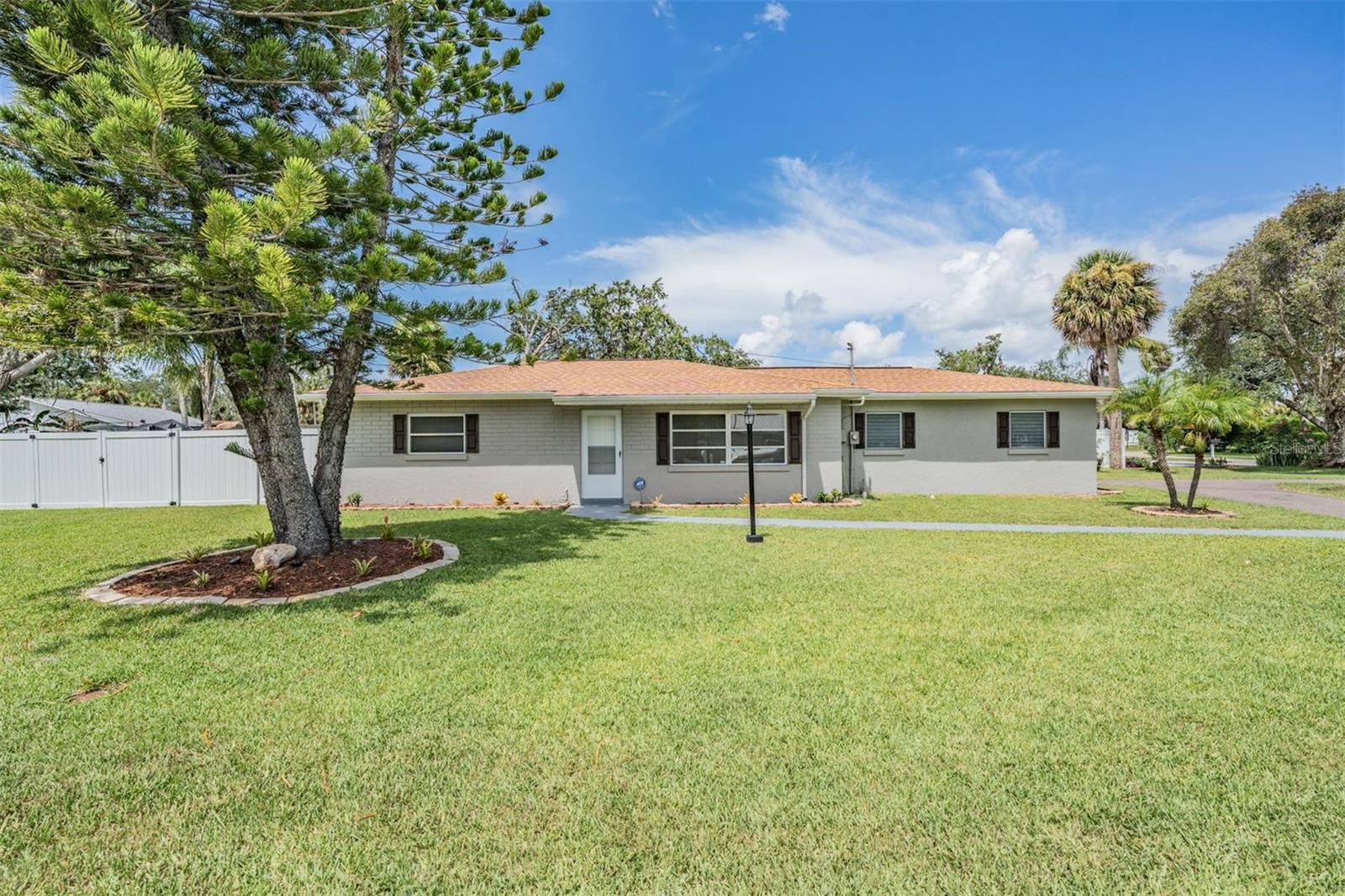 Welcome home to this COMPLETELY REMODELED 3-bedroom, 2-bath beauty that blends modern updates with laid-back coastal charm. Everything in this home has been updated! You don’t have to worry about a thing, just bring your furnishings. The Florida coastal lifestyle is calling you, this property sits less than a mile from the water in this charming, move-in ready block home situated on an oversized ¼-acre corner lot. Updates include a NEW ROOF with hurricane clips, NEW HVAC system with updated ductwork and insulation, NEW fully renovated bathrooms, NEW updated kitchen and appliances, fresh interior and exterior paint, and NEW flooring throughout. A large family room for entertaining, spacious bedrooms, eat-in kitchen, and tons of storage space in the garage make this home perfect for everyone. Out back, enjoy a large fenced-in backyard, as well as a huge front yard and circular driveway with room for all your vehicles and toys. With easy access to major highways, shopping, schools, and dining, this light and bright home offers the perfect balance of comfort, convenience, and coastal living. Schedule your private showing today—this gem won’t last!