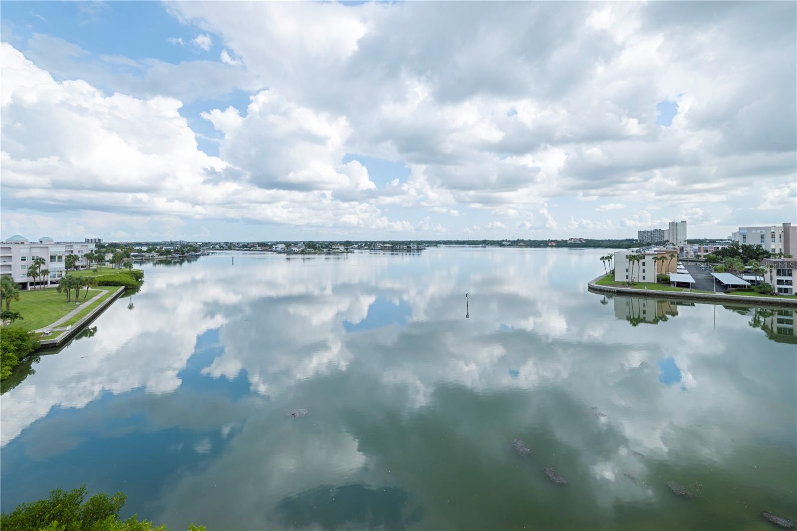 This fifth floor luxury condo has breathtaking views of Boca Ciega Bay. It’s located on a 24 hr Guard Gated island community developed by award winning JMC Communities. This desirable corner unit comes with two balconies, the living room with unobstructed wide water views and the kitchen with dining area overlooking the Marina and clubhouse pool. This is a two bedroom, two bath unit with a den/office/bonus room. All rooms were completely remodeled in 2018. The kitchen has solid wood shaker cabinets with quartz countertops, roll out drawers (soft close) and stainless steel appliances. The main living area is an open floor plan, 9' ceilings throughout and inside laundry. The remodeled primary bathroom features newer stone ceramic tile flooring, a frameless glass shower door, and a newer vanity with granite countertop. The walk in closet is customed designed with glass door enclosed wardrobes. The guest bathroom has been totally updated with newer shower tile, newer vanity with granite counter top, and a new frameless glass shower door. Other improvements include a new HVAC system installed in 2024, a new water heater in 2024, and Hurricane impact windows. There are Hurricane shutters on all of the openings for added protection and peace of mind. The building passed the milestone inspection. The roof on the building was replaced in 2024. The reserved parking space is under the building #119 (is the coveted space by the lobby door). Harbourside is a guard gated (24 hour) complex with many amenities including pool, his and hers fitness centers, shuffleboard, pickleball, tennis, hot tub, electric car charging stations, car wash stations, recently renovated clubhouse with many social events throughout the year, library, card room, billiards room, arts and crafts room, wood working area, yoga and water exercise classes. There is a 1.5 mile walkway around the complex along the waterfront which is lit up for nightly walks. Come see what resort living in Florida is all about. You can live your tropical, island dream here in Harbourside.