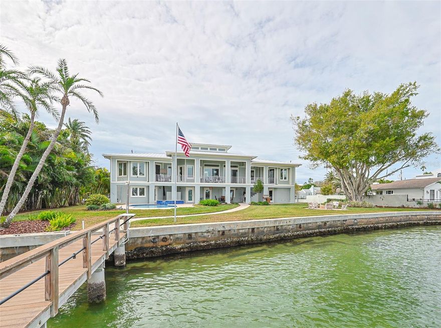 Welcome to this rare and stunning waterfront majestic retreat unlike any other in beautiful Redington Beach!  This gated residence is located on 2.5 lots  of stunning waterfront property, boasting 148.5 feet of waterfront on a natural cove of Boca Ciega Bay. The home sits on a prime piece of land with lovely bay and intracoastal waterway views while also being just a short 600 steps to the extraordinary Gulf of Mexico Beaches. This impressive residence has 3BR/2.5BA on the main level plus another 800+ sq ft of finished bonus space on the lower level with an additional bedroom and full bath! Positioned on a half-acre with over 19,000 square feet and over 7,000 square feet under roof, prepare to be astonished by the high quality, contemporary finishes throughout! This is a solidly built home constructed of concrete block on an elevated lot, which sits 42 inches above street level, has never flooded, and features durable hurricane impact windows throughout the home (no hurricane shutters needed).  No detail has been overlooked, from the sun-filled great room that features 20-foot ceilings to the open concept kitchen with gas appliances, contemporary lighting, and a wonderfully customized pantry. This room accesses the dazzling panoramic views of the bay from the covered deck that runs the length of the house with lots of areas to dine or just take in the beautiful views and wildlife. The spacious primary suite allows you to wake up to an exceptional sunrise water view while providing a luxurious retreat with a backlit tray ceiling, his & hers closets, and a huge primary bath with large soaking tub, separate shower, double vanity, and water closet.  There are 2 more spacious bedrooms on the opposite end of the home, with a shared full bath, zoned A/C, and great storage.  Other amazing interior features include an elevator, Italian porcelain tile flooring throughout, crown molding, solid core doors, central vacuum, and so much more. There is a 4-car garage lined with shelving, an abundance of storage, secondary refrigerator and workshop. While you may never want to leave this prime outdoor space where you can swim in the shimmering Pebble Tec Saltwater pool, soak in the hot tub or just sit by the fire pit in the evening, there is an abundance of walkable restaurants and shops nearby and access to grocery, excellent entertainment, and quality medical care. For those of you who love to go boating this is a true boater’s paradise; this home is just minutes from the Gulf of Mexico & John’s Pass, plus has a large 45 ft dock with 12,000 lb boat lift with water and electricity connected. See this home before it is gone!