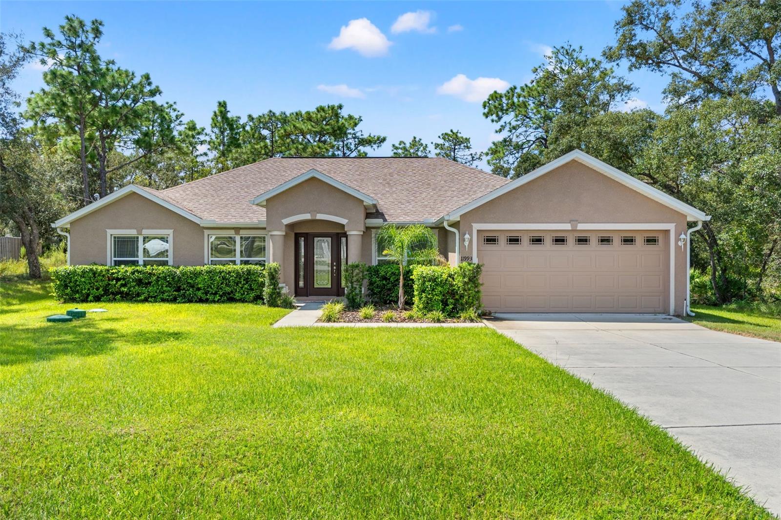 Experience peaceful, country-style living without waiting on new construction at 11993 Robina Road in Royal Highlands, Weeki Wachee / Brooksville. Built by Hartland Homes, known for quality craftsmanship and affordability, this property sits on over a half-acre lot with no HOA restrictions, well water, and a spacious 3 bedroom, 2 bath layout. The home also includes a bonus office/flex room and an inside laundry with utility sink. High and tray ceilings, ceiling fans throughout, and a full sprinkler system in both the front and back yards add comfort and convenience.
The heart of the home is a large, open kitchen designed for everyday living and entertaining. With a center island, abundant cabinet space, and plenty of room to cook, it’s perfect for preparing family dinners or hosting friends. The master suite offers both comfort and functionality with dual sinks, a beautifully tiled walk-in shower, and two closets.
Step outside to a covered rear porch overlooking the peaceful yard, where you can sip your beverage of choice while enjoying the sights and sounds of nature. Set back from the road with lush surroundings, this home offers privacy and space while still being close to paved roadways for easy commuting. Shopping, dining, and everyday conveniences are nearby, along with the natural treasures Hernando County is known for—springs, rivers, parks, and Gulf Coast waterways perfect for boating, kayaking, and exploring.
Whether you’re ready to move in right away, customize with your own personal touches, or invest as a rental, this home delivers space, freedom, and location in one of the area’s most desirable settings. Make your appointment today and bring an offer the seller can’t refuse!
