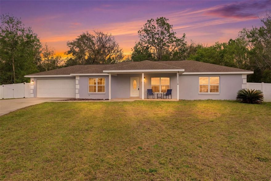 Situated on a quiet cul-de-sac and resting on a spacious 0.34-acre homesite, this well-maintained home offering comfortable living with room to enjoy the outdoors features 3 bedrooms, 2 baths, and a 2-car garage with a split plan layout. A welcoming covered front porch has enough space for furniture to sit outside comfortably to enjoy the beautiful outdoors. Step inside where wood grain tile flooring flows throughout the open space that makes up the living room, dining room and kitchen. This space features a vaulted ceiling and several windows, creating a bright central living space. The dining area sits beside wide sliding glass doors overlooking the backyard and providing direct access to the rear patio while remaining open to the kitchen. The kitchen has a breakfast bar counter, with wood cabinetry lining both sides, tile backsplash along the wall, tile wall, extensive counter space, stainless steel appliances, a pantry between the kitchen and living room, and a double sink positioned beneath a window overlooking the rear yard. The laundry room features corridor access from the kitchen to the garage and features the same tile flooring along with utility cabinets. The primary bedroom includes tile flooring, a wide window facing the front yard, a spacious walk-in closet with built in storage, and an ensuite bathroom. The ensuite bathroom features matching tile flooring, a long vanity with dual sinks and cabinet storage below, a large wall mirror above, and a walk-in shower with tile surround and built-in niche. On the other side of the hallway are the additional bedrooms and shared bathroom. The second bedroom includes tile flooring, a window facing the front yard, and a built-in closet. The guest bathroom features tile flooring, a double sink vanity with cabinet storage below and a large mirror above, along with a tub and shower combination with tile surround. Bedroom three includes wood-look tile flooring, two windows on adjacent walls bringing natural light and yard views, and a built-in closet, making it also suitable for use as an office or flexible room. Sliding glass doors from the dining area open to the rear patio with a view of the wide backyard enclosed by white vinyl fencing and trees behind the boundary line, providing shade across the yard Located in Lecanto, the property provides convenient access to the Suncoast Parkway for travel toward Tampa and surrounding areas. Nearby attractions include the Withlacoochee State Trail offering miles of paved paths for biking and walking, Crystal River known for boating and manatee tours in its clear spring waters, and Homosassa Springs Wildlife State Park where visitors can enjoy nature trails and native wildlife exhibits, offering a lifestyle that blends quiet residential living with outdoor recreation and nearby conveniences.