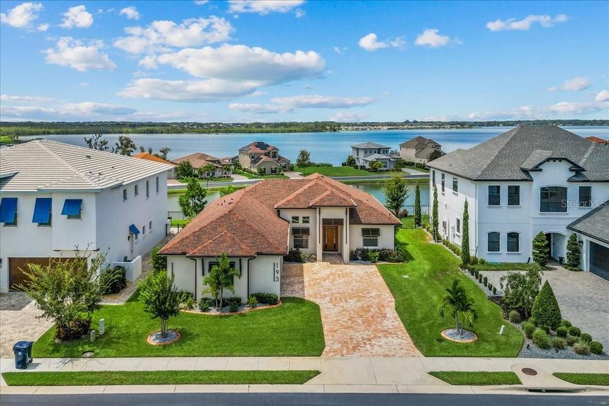 Modern design meets resort-style living in this custom home built in 2023. From the moment you enter, the open layout and walls of glass draw your eye to the water views beyond, creating a natural connection between indoor and outdoor living. The centerpiece of the home is a chef inspired kitchen featuring an oversized waterfall island, European cabinetry, stone counters, and premium appliances, designed for both beauty and functionality. The great room opens seamlessly to an expansive lanai, complete with outdoor kitchen, fireplace, and bamboo flooring perfect for gathering with friends or relaxing as the sun sets over the water. The owner’s suite feels like a private spa, with its wet-room bath, dual shower heads, towel warmer, and floating double vanities. Three additional bedrooms and baths are equally refined, offering flexibility for family, guests, or a home office. Natural gas throughout the home adds convenience and efficiency, powering the kitchen, lanai, fireplace, and tankless water system. Set within the exclusive Water Ridge gated community, you’ll enjoy access to pools, a fitness center, tennis and pickleball courts, a sauna, clubhouse, and multiple lakes for boating and fishing. Every detail of this home has been designed for a lifestyle of comfort, style, and ease.