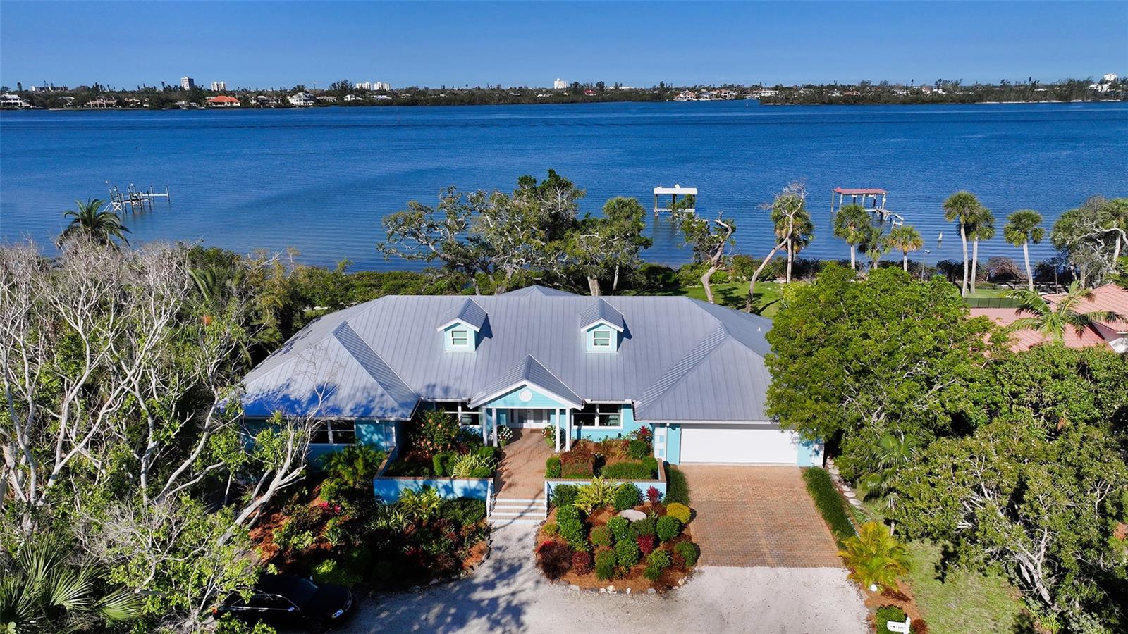 Located in one of Sarasota’s most prominent neighborhoods, this property enjoys a postcard-like setting featuring wide-open bay views on over an acre of land. Positioned in close proximity to The Field Club, the property enjoys approximately 200 feet of natural shoreline, a 150+ ft. long boat dock which is being restored, and a beautiful backyard with mature landscaping. There are Bay views from all major rooms through walls of glass. The home is in like-new condition with all major components and systems being replaced in 2017. The open floor plan has a great flow and provides privacy for owners and guests alike in three en-suite bedrooms. Island style describes the décor with fine textured wall coverings and high end finishes. Trey ceilings, crown moldings, artistic lighting, and custom built-ins are featured. The kitchen is a cook’s delight and is flanked by a lovely breakfast room on one side and the dining area on the other. The expansive Great room is perfect for entertaining guests or having the family together for Saturday night at the movies. The laundry room is positioned just off the kitchen leading to the garage. A terrific air conditioned attic area is perfect for storing luggage, holiday decorations and the like. The two car garage is attached with an additional air conditioned workshop which could double as a 3rd car garage. The property is located along this specific area of shoreline with significantly more expensive homes and has been priced to sell. A serious opportunity in a truly iconic setting.