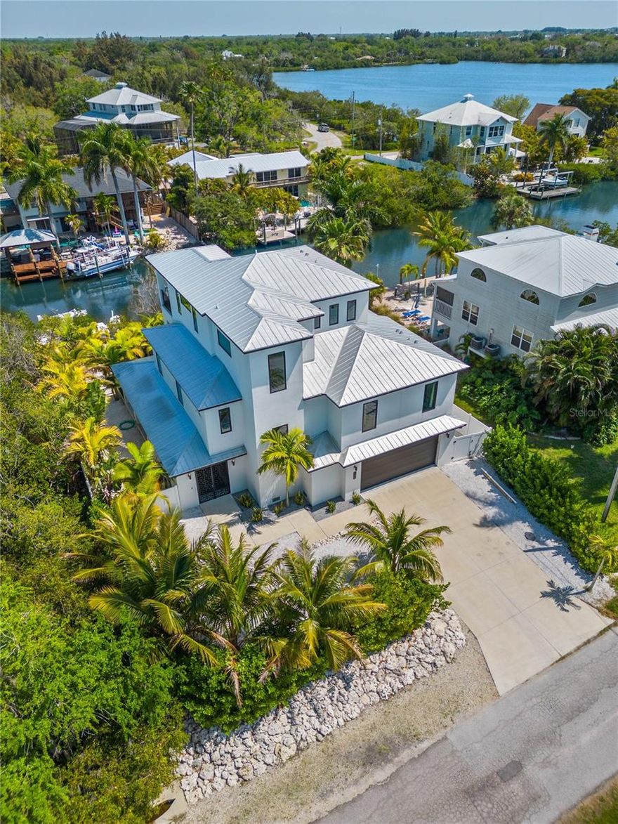 Welcome home to idyllic Terra Ceia Island! Remaining high and dry without damage from any 2024 storms, this contemporary masterpiece brings modern luxuries to this beloved, “Old Florida” neighborhood. Constructed to the highest standard, this three-story, pool home seamlessly blends indoor and outdoor living spaces with impact windows throughout, pocketing impact-sliding doors and over 2,500 square feet of courtyard/lanai space! The custom front gate leads you to an expansive, covered lanai overlooking the private pool and Xeriscaped backyard. An environmentally safe insect repellant system means you’ll have maximum comfort in all the outdoor living spaces. A boater's paradise with 85 feet of canal frontage and a 70-foot dock with 10,000lb boat lift in addition to water and electrical connections. There is also a second set of moorings that can be finished to fit the buyer’s watercraft needs! The first floor boasts office space with a mini-split A/C unit and a half bath that is also accessible to the pool. This spacious home has an open floor-plan to entertain guests, tile flooring throughout for low maintenance and offers endless canal and bay views. The second-floor features: two large secondary bedrooms each with their own walk-in closet and connected with a Jack-and-Jill bath, an additional powder room for guests as well as a large laundry room. A true Chef’s kitchen with state-of-the-art JennAir appliances including gas range, oven, fridge/freezer – all built into custom cabinetry. The third level is entirely dedicated to the primary suite and a landing foyer for the private elevator. Offering views of the Sunshine Skyway to the Northwest and Canal/Bayou views to the South and East, the primary suite offers the perfect, private retreat to unwind. A designer primary bathroom that dreams are made of, including a triple-head shower, oversized tub with a view, personal wine refrigerator and separate vanities. Step through sliding doors into a massive walk-in primary closet equipped with built-in drawers and additional storage. A private balcony overlooking the canal provides the perfect location to wind down and get one last taste of paradise for the day! Ideally located just minutes from the Sunshine Skyway with easy access to the I-75/275 corridor, St. Petersburg, Tampa and Sarasota/Bradenton!  Don’t let this once in a lifetime opportunity pass you by!