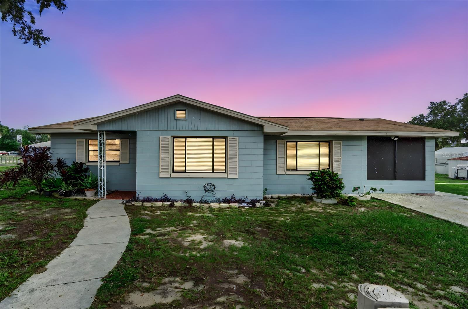 One or more photo(s) has been virtually staged. Welcome to this beautifully maintained 3-bedroom, 2-bath block home situated on a fully fenced 0.21-acre corner lot in Davenport with no HOA. Boasting over 1,050 sq.ft. of interior living space, this bright and spacious residence features elegant wood-look ceramic tile flooring throughout, fresh neutral paint, updated lighting fixtures, and a large open-concept living and dining area filled with natural light from multiple windows. Both bathrooms are tastefully finished—one offering a tiled walk-in shower and the other with a full tub setup. A screened-in lanai provides the perfect spot to relax and enjoy the outdoors year-round. A standout feature is the detached, climate-controlled studio with split A/C, tile floors, modern LED lighting, and custom workspace installations—ideal for a beauty salon, nail studio, home office, or creative business setup. With driveway parking, mature shade trees, and proximity to major roads, schools, and shopping, this move-in-ready home offers a unique combination of comfort, utility, and business potential, all within a peaceful residential setting.