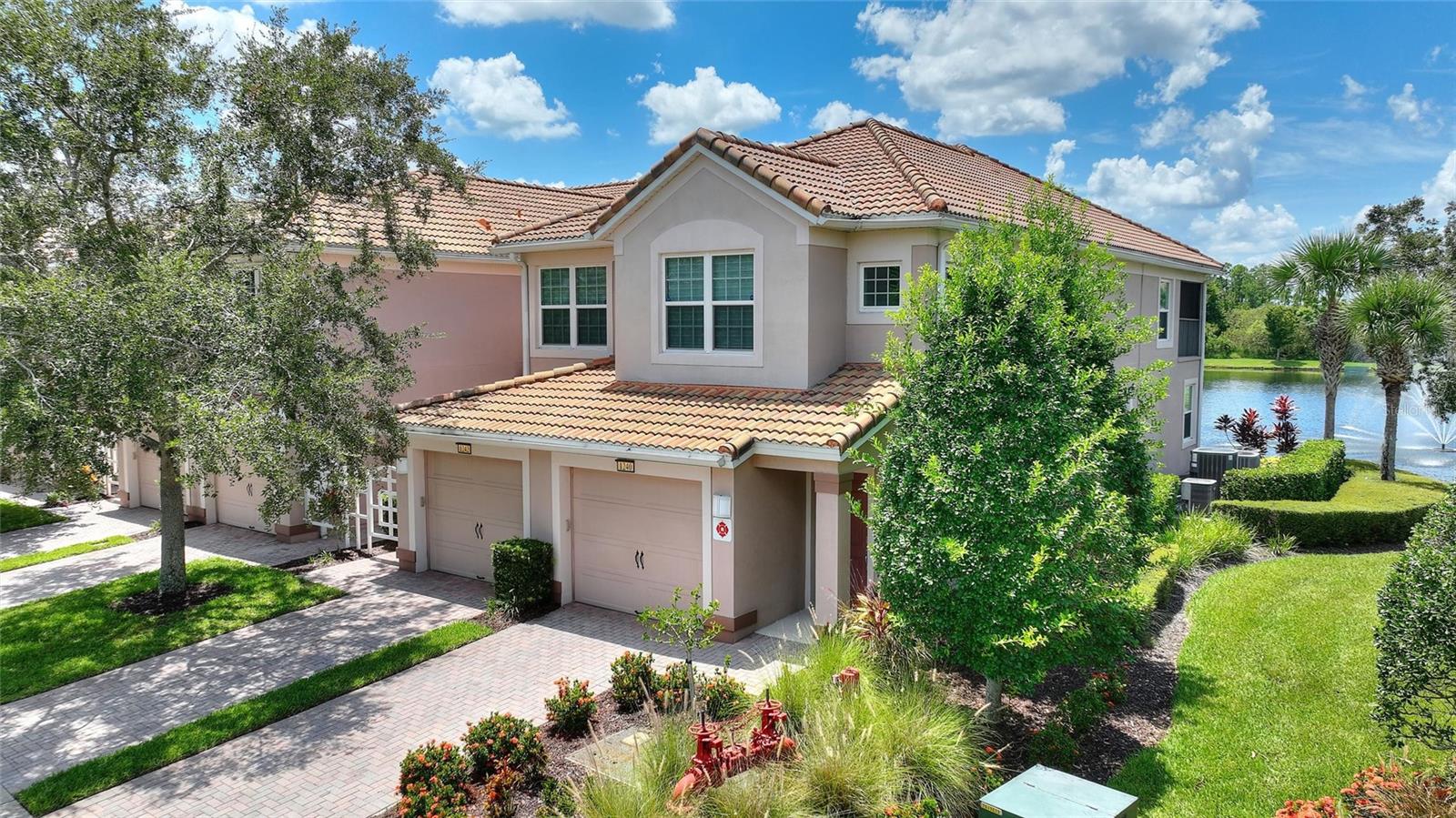 MOST DESIREABLE WATER FRONT CONDO WITH A LOVELY FOUNTAIN VIEW END UNIT. This condo features 2 bedroom 2 bath + BONUS room that can be utilized as 3rd bedroom . Move-In-Ready first floor condo with attached garage with speckled flooring, brick paver driveway in the upscale Bella Trae guard gated community designed by the Famous Del Webb of Champions Gate. An open floor plan with an abundance of natural light and killer views of the natural green space, water front, and lovely fountain to listen to each day. A spacious kitchen with 36" wood cabinets, crown moldings, solid surface counters and stainless appliances. Ceramic tile in wet areas, and premium Luxury Vinyl planks throughout the home (NO CARPET). New neutral color designer interior paint, nice spacious interior floor print designed with room for everyone in the family. You can sit out on your private screened lanai for evening cocktails and enjoy the life you deserve. The upscale Bella Trae community in Champions Gate features premium amenities to include an activities director, Olympic size outdoor heated pool/spa for your daily exercise, a state of the art fitness center, tennis, pickleball courts, billiards room, library, bocce ball tournaments, and finally a Golf putting green for practice. Bella Trae is truly the most desirable upscale community in the area, and you can walk to an abundance of chosen restaurants on Champions Gate Blvd. If you enjoy golfing , just across the street is the Omni hotel golf resort. You can make a reservation to play golf and socialize. Owning a Condo in Bella Trae is a owning experience second to none, a Condo you can be proud to bring guest, family and relatives. Minutes from Disney, and other area attractions , with easy access to I-4 east and west. Call to have a look at this well maintained , move in ready unit for a primary, vacation second home, or a great investment to lease out.