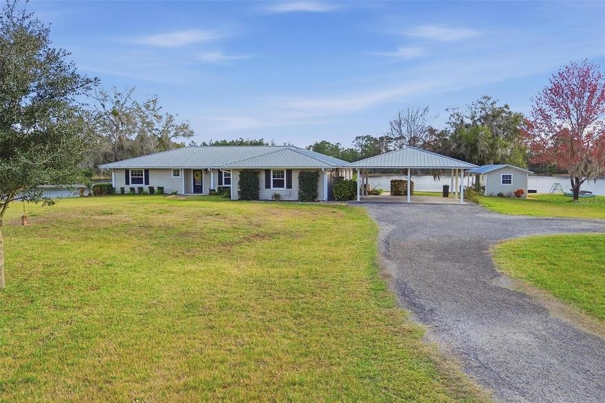 Set behind a private gated entry on 4.33 breathtaking lakefront acres, this exceptional 4-bedroom, 2-bath, 2,663 sq ft estate offers a rare blend of refined living, privacy, and natural beauty—just minutes from the charm of downtown DeLand. Designed to capture panoramic water views, the living room is lined with expansive windows overlooking the lake, creating a stunning backdrop and flooding the space with natural light. Rich wood flooring throughout the home adds warmth and timeless elegance.

The chef-inspired kitchen is both functional and inviting, featuring stainless steel appliances, a built-in oven, spacious center island, and an eat-in dining area ideal for everyday living or entertaining. The luxurious primary suite serves as a private retreat, complete with serene lake views, oversized windows, custom built-ins in the walk-in closet, and a spa-like ensuite bath showcasing a soaking tub, beautifully remodeled walk-in shower, and dual vanities.

Additional interior highlights include an indoor laundry room and thoughtful layout offering comfort and flexibility for family or guests. Outside, the property continues to impress with a metal roof, whole-home Generac generator, covered 2-car carport, detached shed/workshop, and a private wood dock extending onto the lake. The expansive screened-in back patio provides the perfect setting to unwind or entertain while enjoying tranquil water views and unforgettable sunsets. This is lakefront living at its finest—private, peaceful, and effortlessly elegant.