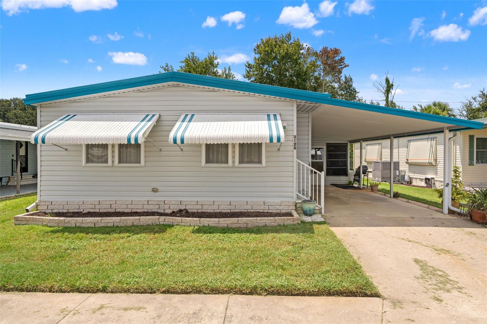 Stunning lakefront views at an attractive price! Welcome to 3125 Birkdale Drive, a perfectly cozy home for living the retirement or snow bird lifestyle! This home features 2 bedrooms and 2 bathrooms, with plenty of living space! As you pull up you'll be greeted by a large carport, with plenty of room to park your cars! Not only that, walk through your screened in lanai that can be used as a mud room, into a large storage shed with plenty of shelving! Let's step inside, your living room is nice and open with vaulted ceilings and enough natural light and windows that you'll never want to keep your lights on during the day! Towards the kitchen you'll notice a comfortable dining room area right off the kitchen, perfect for serving food and easy access for guests! Your two bedrooms are located in the back of the home, with your primary bedroom featuring stunning views of the backyard, as well as the primary bathroom. Stepping outside, you'll see your screened in lanai with a view of trees, and not far at all from lakes to enjoy beautiful waterfront views on a sunny day. With benches at every lake, this community is perfect for relaxing and living up the Florida lifestyle! This home has a low monthly HOA of only $143, but so many amenities come with it, including a heated pool, lawn maintenance, trash pick up, clubhouse, shuffleboard courts, and ground maintenance! If you are looking to live the Florida lifestyle at an amazing price, call today to make this one yours! You won't want to miss it!