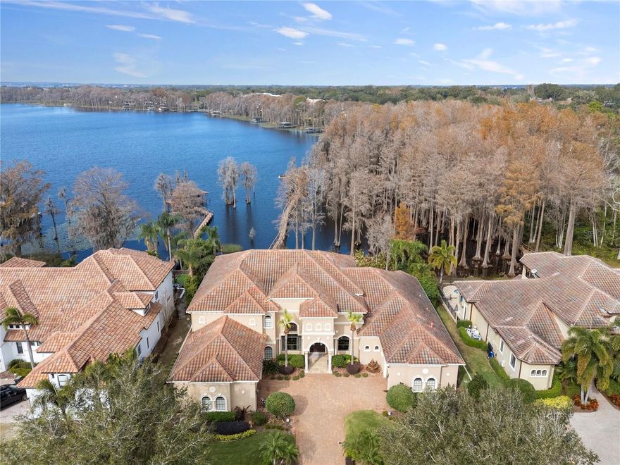 Exceptional opportunity on the Butler chain of Lakes with amazing views and 115 ft of frontage!!! Enjoy golf in the morning at Bay Hill Country Club and the afternoon on the lakes with your family and friends.  This meticulous residence features 5 bedrooms 6.5 bath plus game room/movie theater.  Open plan with soaring ceilings and views of the Butler chain from almost every room.  Also, just minutes to the many dining/shopping options on Sand Lake Rd.  This exceptional home features exquisite finishes including stone and wood flooring, a spacious first-floor game room with a wet bar, and a flex/home theater on the upper level. Two elegant fireplaces set the tone for a warm and inviting atmosphere. Step outside to enjoy the open pool and spa with stone accents, a seawall, and a boathouse with a dock offering 115 feet of pristine Lake Blanche frontage.  The outdoor summer kitchen is ideal for entertaining, while the state-of-the-art gourmet kitchen boasts a commercial-grade gas stove, designer hood, custom cabinetry, granite countertops, and a large island perfect for both cooking and gathering. A dramatic staircase with stone details and an iron railing leads you to the upper levels.  The oversized primary bedroom and bath are a true sanctuary, featuring a spacious bedroom with sitting area, lots of windows for the views and natural light while the bathroom features a Jacuzzi spa, a luxurious oversized shower, and two expansive walk-in closets. A versatile flex space with private access to one of the three-car courtyard garages provides convenience and flexibility.  In addition to the primary suite, the home offers a guest suite on the main level that doubles as a secure safe room, while three additional guest suites are situated upstairs. This extraordinary residence seamlessly blends unparalleled lakefront living with proximity to world-class amenities, offering the ultimate in luxury and location for those seeking the finest in both comfort and convenience.