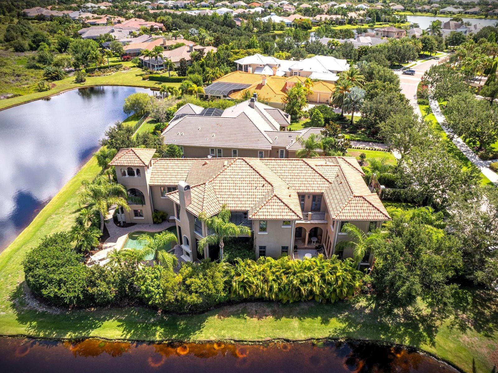You can't always get what you want....but this house is definitely what you need! Hamrick / Jagger
This magnificent, custom built Rutenburg home in the premier gated community of The Lake Club was built with privacy in mind. Exceptional lot with serene water views on two sides, a beautifully landscaped linear park across the street & only one neighbor. As you enter the front door you will be in awe of the unique architecture & attention to detail which defines this amazing house along with its unique history! Two sets of French Doors take you into a private courtyard surrounded by lush Florida landscaping for total peace & privacy. 5700+ sq feet of remodeled light & airy excellence, 4 en suite Bedrooms (all w/ walk in closets), 5.5 Baths, Study, Great Room, Den, and expansive entertaining media room w/ full wet bar & full bath perfectly situated on .35 of an acre (15,245 sq ft). 3 Balconies, screened Lanai & it's very own bell tower w/ spectacular sunset views complete the outdoor living. 2 professional decorators & $400K+ later this house is as comfortable as it is elegant and a must see. Newly screened in lanai with fireplace and kitchen is perfect for entertaining with a lovely view of the open-air Salt water, heated, Pool. Enjoy 12 ft ceilings w/ Crowne molding, dramatic coffered ceilings thru the great room & kitchen. This house has been completely remodeled by not one but two designers over the past 2 years. Curated professional lighting, full interior painted, Pocket doors added, Dark wood lightened, & extensive landscaping, security cameras & gates added. Every chef's dream is this custom kitchen w/ Sub Zero, Viking, Wolf and Miele appliances, ample cabinetry, oversized island & 2 walk in pantries. Gas Viking stove, warming drawer, convection oven and a cappuccino machine make this kitchen perfect for gathering with friends and family. This oversized Owner's Suite is the perfect oasis at the end of the day with its private large balcony w/ fireplace and breathtaking backdrop water sceneries. New custom darkening remote powered window treatments, walk in closet and private staircase round out this elegant room. Impressive mast bath w/ dual granite vanities, soaking tub, and a lg walk in Rain Shower. As a hidden bonus this house has an oversized Entertainment/Media room w/ a large wet bar, full bath & private staircase leading to it. The possibilities for that room are endless. The more you explore this property the more you will fall in love! Come Home to the gated community of the Lake Club (LWR most exclusive community) and enjoy an elevated life-style with its Newly remodeled 20,000 sq ft Grand Clubhouse, Resort Style Pools, private Tennis Courts, Dining, Social Activities and Fitness Center. Room Feature: Linen Closet In Bath (Primary Bedroom).