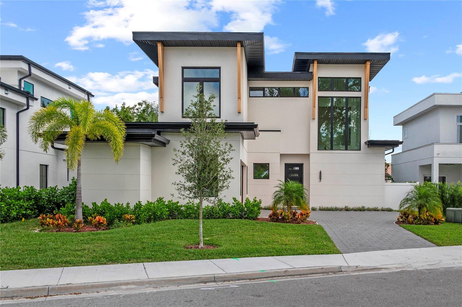 Discover sophisticated modern living at 607 Ellen Drive, a stunning new construction home by the acclaimed Lazarus Homes in the heart of Winter Park. This impeccably designed 2,812-square-foot residence showcases contemporary architecture with clean lines, high ceilings, and an abundance of natural light throughout. The open floor plan seamlessly connects living spaces, creating an ideal setting for both everyday life and elegant entertaining.
The chef's kitchen is a true showpiece, featuring top-of-the-line Monogram appliances, a sleek Ruvati sink, built-in oven and microwave, and a professional gas range. Gorgeous Taj Mahal Quartzite countertops provide both beauty and durability, while thoughtful design elements include the option for a full-height wine refrigerator or additional cabinetry to suit your lifestyle. The living room offers a modern ambiance with an electric fireplace and expansive glass sliders that open to a covered lanai overlooking your private pool—perfect for Florida's indoor-outdoor lifestyle. For those who love to entertain, the home has been pre-stubbed for an optional outdoor kitchen.
The luxurious first-floor primary suite provides a private retreat with a spa-inspired en suite bath featuring a double sink vanity, walk-in shower, soaking tub, and an oversized walk-in closet complete with custom built-ins and convenient washer and dryer hookups. Upstairs, the home continues to impress with a generous bonus room, a sophisticated loft with glass walls, three additional bedrooms, two full baths, and a second laundry area for ultimate convenience. A dedicated pool bath adds another layer of functionality for poolside enjoyment.
Nestled in the desirable Lake Killarney Shores community, this home offers the perfect blend of tranquility and accessibility. Residents enjoy a low HOA, private boat launch access to Lake Killarney, and the convenience of being within walking distance to Winter Park's renowned restaurants, boutiques, and cultural attractions. This is move-in ready modern luxury at its finest.