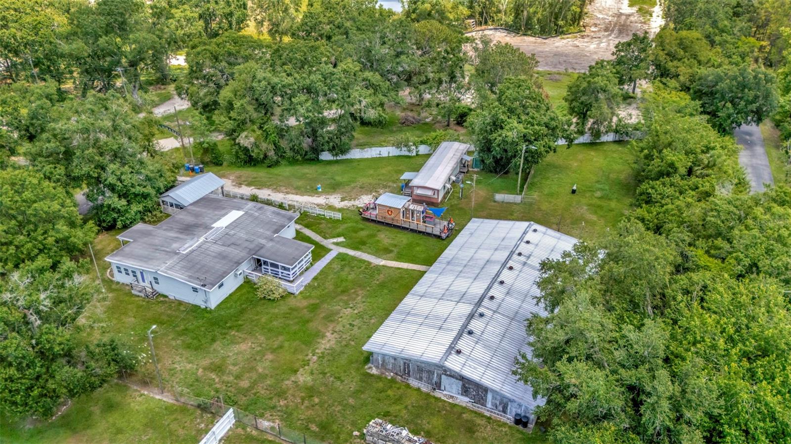 Incredible development/investment opportunity in the heart of Tampa! Situated on a nearly 1-acre lot in the quiet Green Grass Acres community, this versatile property features TWO mobile homes plus a massive 4,732 sq ft steel utility/storage structure—offering endless possibilities for personal use, income generation, or redevelopment.