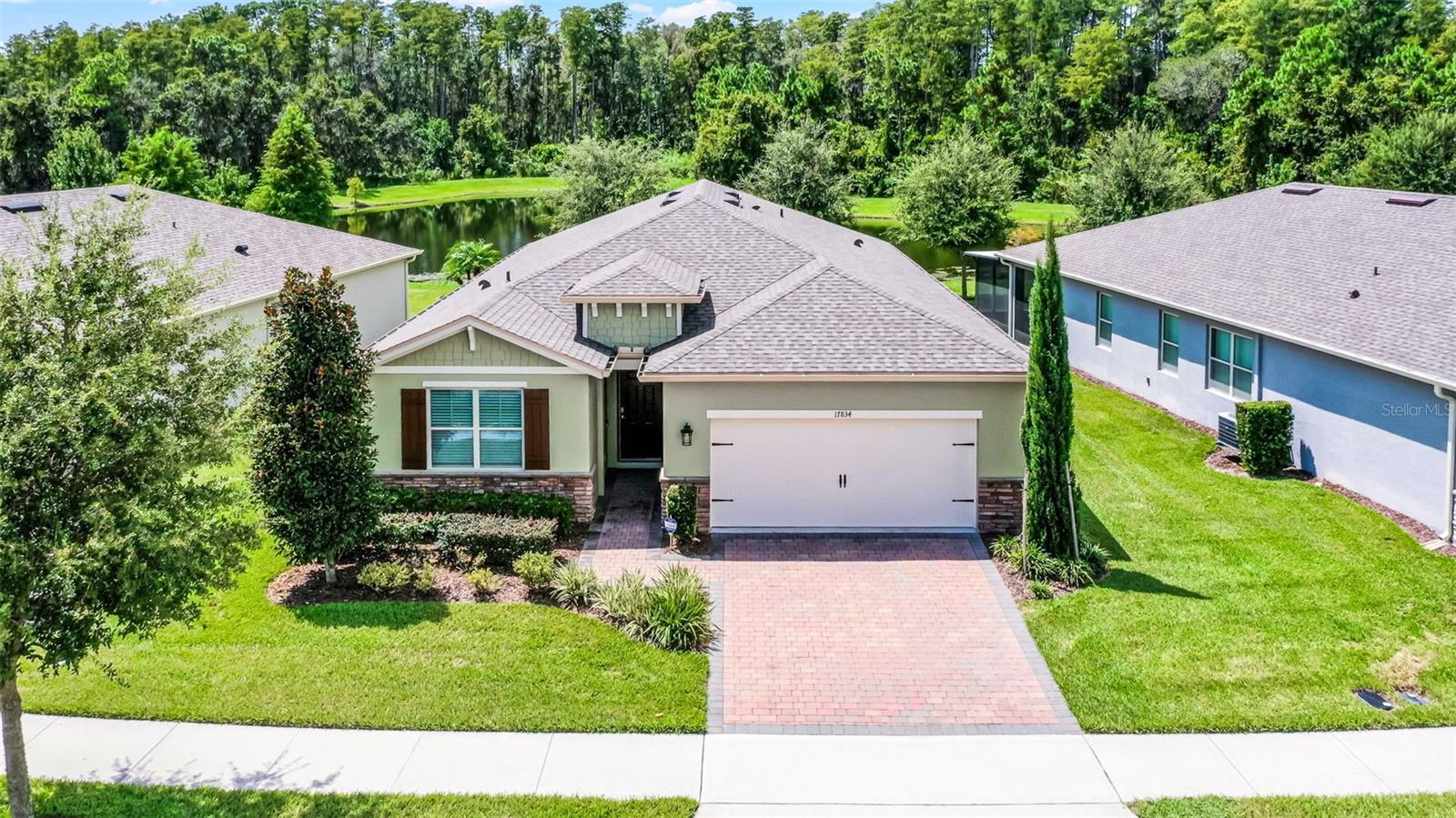 Water & Conservation Views – Premier Lot! Welcome home to the largest floor plan in The Palms at Serenoa, Clermont’s premier 55+ gated community offering resort-style living just 25 minutes from Walt Disney World.
This stunning four-bedroom, two-bathroom single-story home offers 2,034 square feet of open living space on a premier waterfront lot with tranquil conservation views. The stone elevation, paved driveway, and fresh exterior paint completed in 2025 create beautiful curb appeal. Inside, extended wood-look tile floors, eight-foot doors, and abundant natural light flow through an open-concept design that seamlessly connects the great room, dining area, and gourmet kitchen.
The kitchen is a showstopper with a large quartz island, stainless steel appliances, upgraded 42-inch soft-close cabinets with crown molding, a beautiful backsplash, and a custom walk-in pantry. The spacious dining area features a picturesque window overlooking the water and opens into the inviting living room. From there, sliding doors lead to the screened and covered lanai with brick pavers—the perfect spot for morning coffee or evening relaxation while enjoying serene water and nature views.
The private primary suite is tucked at the rear of the home with peaceful water views and two walk-in closets. Its beautifully appointed bathroom includes a large walk-in shower, dual sinks, an expansive vanity, and a private water closet. Three additional bedrooms and a second full bathroom provide flexible space for guests, hobbies, or a home office, while the laundry room with a utility sink adds convenience.
Thoughtful upgrades elevate this home, including a new roof and gutters installed in 2023, a whole-house water filtration and softener system added in 2025, fresh exterior paint, and a 15 SEER AC. With no waiting for construction and a premier lot location, this home is move-in ready.
Life at The Palms at Serenoa is centered around an active lifestyle. Residents enjoy a heated resort-style pool with lap lanes, a state-of-the-art fitness and yoga studio, pickleball and bocce courts, a clubhouse with activity rooms, and a full-time lifestyle director who plans daily events and social gatherings. Scenic walking and biking trails, dog parks, and the convenience of included lawn care and internet make life here truly effortless.
With just 570 homes, the community provides an intimate neighborhood feel while keeping you close to everything Clermont has to offer. The upcoming Sawgrass Boulevard extension will provide direct access to Winter Garden, Horizon West, and Disney, while Historic Downtown Clermont offers charming restaurants, boutique shopping, a weekly farmers market, and beautiful waterfront parks. You’ll also be just minutes from the upcoming Olympus in Clermont, a fully integrated destination offering an array of health, wellness, sports, and entertainment facilities that will bring exciting new amenities and experiences to the area.
This home combines a premier lot, modern upgrades, and a vibrant 55+ lifestyle in a gated community that truly has it all. Schedule your showing today!