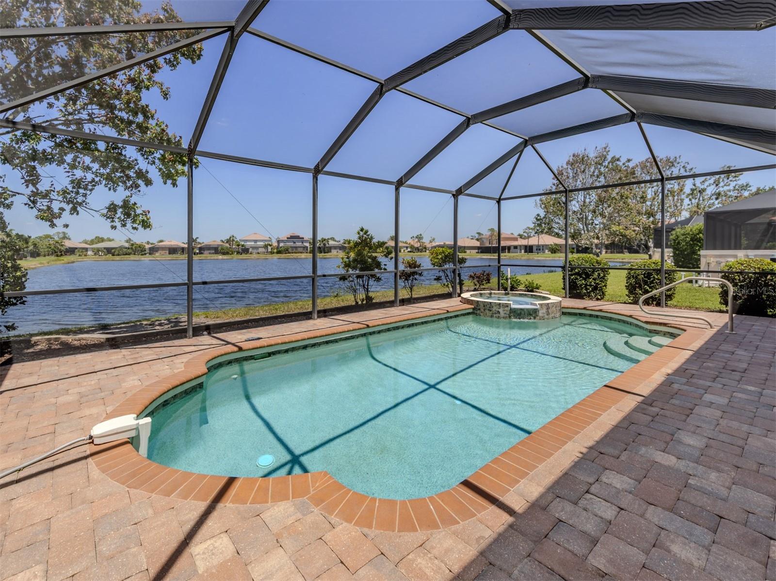 STUNNING WATER VIEWS!!! Discover the epitome of Florida living in this 1,680-square-foot, hurricane-protected, beautifully appointed, with two bedrooms, two baths, den, turnkey, heated pool home in the gated community of Stoneybrook at Venice. This long-water view home combines modern upgrades, elegant wood and tile flooring throughout, and serene north-facing lanai with long water views, ideal for everyday enjoyment of the pool and lanai. The open concept layout features a living room, family room, versatile den, all enhanced by stylish wood and tile flooring that adds warmth and easy maintenance. The family room boasts sliding glass doors that open to a screened lanai complete with heated pool and spa creating a seamless indoor-outdoor living experience. The primary suite, at the back of the home offers tranquil lake views, walk-in closet, a private en suite with dual sinks and walk-in shower. The second bedroom at the front of the home near the second full bath is ideal for guests or family, while the den provides flexible space for a home office or hobby room. The gourmet kitchen shines with a breakfast nook, pantry, built-in desk, raised opaque panel cabinetry, stainless steel appliances, reverse osmosis filtration system and breakfast bar that overlooks the family room. The laundry room with extra cabinetry for storage leads to the two-car garage featuring extended storage space for bikes, beach chairs and more. Modern upgrades include 2022 air conditioner, 2017 photovoltaic solar system (paid in full), 2024 pool heater, Rinnai tankless water heater with Culligan sediment filter, ensuring efficiency and comfort. Delivered fully furnished in turnkey condition, this home is move-in ready. Stoneybrook at Venice is a family-friendly community with many amenities such as a guarded gate, community center, fitness center, CATV, gathering room with kitchen, movie room, resort-style pool, hot tub, splash pool, sand volleyball, playground, ball fields, splash park and pickleball courts coming soon as monies have been allocated. Close to Interstate 75 and downtown Venice, the newly built Sarasota Memorial Hospital, shopping, dining, pristine Gulf beaches, Sarasota County's A-rated schools and Atlanta Braves spring training ballpark.
