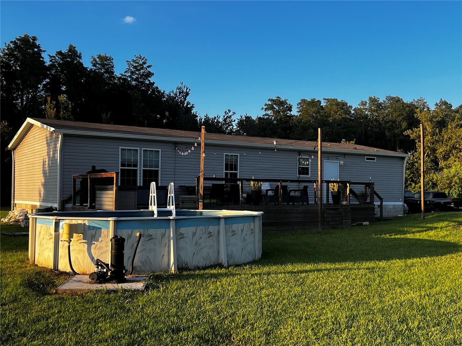 Move-in ready 3-bedroom, 2-bath home on 4.75 acres in a very private and secluded setting of St. Cloud, Osceola County. Built in 2020, this well-maintained manufactured home offers 1,456 square feet of living space with an open floor plan, split bedrooms, and beautiful crown molding. The spacious eat-in kitchen is perfect for gathering, while the living area features a built-in electric fireplace for cozy evenings. The laundry room includes a deep utility sink for added convenience. Interior features include carpet and linoleum flooring, window treatments, and an energy-efficient thermostat. Zoned Agricultural (AC), this property is ideal for pets, livestock, or small-scale farming, and it is located within a USDA-eligible area. A rare opportunity to own nearly 5 acres with true privacy, while still being close to shopping, dining, and conveniences in St. Cloud.