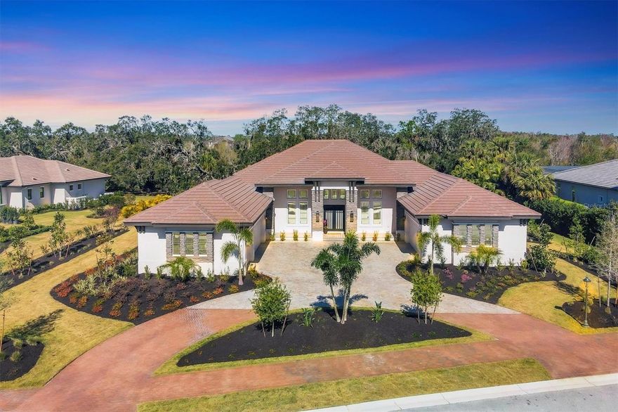 Welcome to 3927 Founders Club Drive, a newly constructed masterpiece in The Founders Club. Nestled on a private estate lot, this stunning residence boasts 4,862 square feet of expertly crafted living space. Featuring four bedrooms and five-and-a-half bathrooms, this home includes garage space for 5, dedicated His and Her studies and a versatile bonus room. With a backdrop of 100 year old oak trees and peaceful lake, this home is perfectly positioned on over a ½ acre. The West Indies design elements exude warmth, highlighted by soft stacked stone and a charming front porch that invites you in. The iron and glass front entry doors set the stage for luxurious finishes throughout. Stained open truss beams create a dramatic entrance to the Great Room, which flows seamlessly to the rear lanai. The neutral wood flooring adds warmth, complemented by 10-foot sliding glass doors, a gas fireplace, and a vaulted ceiling, making this space both inviting and sophisticated. The Breakfast Kitchen is a culinary dream, complete with custom built-ins, a massive island with seating, and a picture window that connects to the Chef's Kitchen. Designed for the passionate cook, the Chef's Kitchen features a professional-grade gas range, wall ovens, a cabinet panel refrigerator, elegant quartz countertops, and a spacious walk-in pantry. With three skylights and a large picture window, this space is flooded with natural light, creating a vibrant atmosphere. The primary suite is a true oasis, showcasing His and Her separate full bath retreats, each with fully outfitted walk-in closets. A cozy sitting area offers a peaceful retreat with views of the majestic oak hammock outside. The bonus room, featuring disappearing glass corners, opens to an artfully designed outdoor kitchen, complete with a professional grill, two cooling drawers, and dedicated ice maker, all finished with luxury touches. The clear-view screen protects the resort pool with an infinity-edge spa, providing tranquil vistas of the 100-year-old oak trees and serene lake beyond. With a level of fit and finish that must be seen to be truly appreciated, this home offers warmth and peace of mind, featuring a whole-house generator, foam insulation, whisper quiet HVAC units and impact-resistant Low E windows and doors for optimal efficiency and security. Conveniently located just minutes from University Town Center shopping, the vibrant arts and entertainment of downtown, and our award-winning beaches, The Founders Club is a prestigious, 24-hour manned gated community. Residents have the opportunity to enjoy exceptional golf and club amenities, making this an ideal setting for both relaxation and recreation. Experience the perfect blend of luxury and lifestyle at 3927 Founders Club Drive!