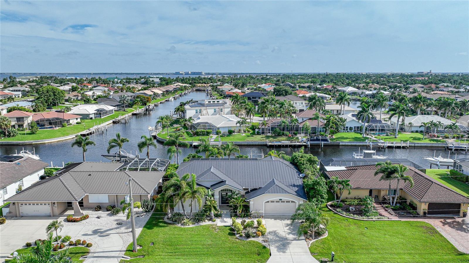 Welcome to your dream waterfront home in the highly coveted Punta Gorda Isles! This exceptional move-in-ready property boasts everything you’ve been envisioning for luxurious, waterfront living. This stunning residence offers 3 spacious bedrooms, 2 well-appointed bathrooms, and a 2-car garage, all gracefully positioned on a picturesque canal with direct Gulf Access. Step outside to your private 45-foot concrete dock, featuring water and electricity, a 10,000lb boat lift, and a concrete seawall maintained by the City of Punta Gorda. With these premium features, you'll enjoy effortless access to the Gulf of Mexico. Recent enhancements include a new metal roof and a Generac Generator, ensuring peace of mind and durability. Upon entering, you are greeted by double doors leading into a bright and airy living room, accentuated by vaulted ceilings and elegant tiled floors throughout. The expansive sliders offer breathtaking views of the lanai and canal, seamlessly blending indoor and outdoor living. Host unforgettable gatherings in the formal dining room, or prepare meals in the gourmet kitchen, complete with abundant cabinetry, granite countertops, a breakfast bar, built-in desk, an island, a walk-in pantry, and high-end stainless-steel appliances including a new induction range. The kitchen flows effortlessly into the family room, where you can savor stunning canal views. The master suite is a serene retreat, featuring a bay window, a cozy sitting area, plush carpeting, and private access to the lanai. The luxurious ensuite bathroom boasts dual walk-in closets, an L-shaped vanity, a soaking tub, and a separate shower. The thoughtful split bedroom floor plan offers privacy for guests with two additional bedrooms and an updated second bath. The expansive screened-in lanai is perfect for entertaining, complete with a new tiki bar, fresh tile flooring, a remote-controlled awning, and panoramic water views. There's ample space to add a hot tub, enhancing your outdoor living experience. Additional features include public water and sewer, no HOA fees, fresh window treatments with remote blinds, and a convenient laundry room with newer appliances. Don’t miss this incredible opportunity to own a slice of paradise. Schedule your showing today and discover all the exceptional features this waterfront gem has to offer!