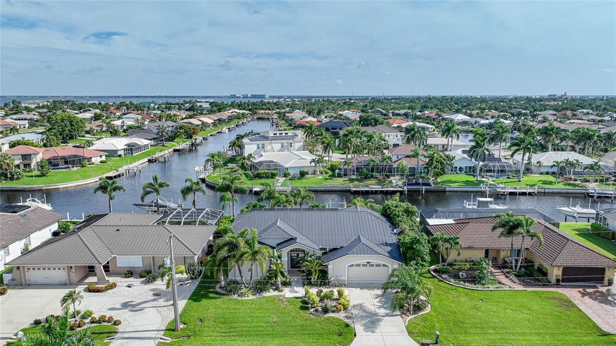 Welcome to your dream waterfront home in the highly coveted Punta Gorda Isles! This exceptional move-in-ready property boasts everything you’ve been envisioning for luxurious, waterfront living. This stunning residence offers 3 spacious bedrooms, 2 well-appointed bathrooms, and a 2-car garage, all gracefully positioned on a picturesque canal with direct Gulf Access. Step outside to your private 45-foot concrete dock, featuring water and electricity, a 10,000lb boat lift, and a concrete seawall maintained by the City of Punta Gorda. With these premium features, you'll enjoy effortless access to the Gulf of Mexico. Recent enhancements include a new metal roof and a Generac Generator, ensuring peace of mind and durability. Upon entering, you are greeted by double doors leading into a bright and airy living room, accentuated by vaulted ceilings and elegant tiled floors throughout. The expansive sliders offer breathtaking views of the lanai and canal, seamlessly blending indoor and outdoor living. Host unforgettable gatherings in the formal dining room, or prepare meals in the gourmet kitchen, complete with abundant cabinetry, granite countertops, a breakfast bar, built-in desk, an island, a walk-in pantry, and high-end stainless-steel appliances including a new induction range. The kitchen flows effortlessly into the family room, where you can savor stunning canal views. The master suite is a serene retreat, featuring a bay window, a cozy sitting area, plush carpeting, and private access to the lanai. The luxurious ensuite bathroom boasts dual walk-in closets, an L-shaped vanity, a soaking tub, and a separate shower. The thoughtful split bedroom floor plan offers privacy for guests with two additional bedrooms and an updated second bath. The expansive screened-in lanai is perfect for entertaining, complete with a new tiki bar, fresh tile flooring, a remote-controlled awning, and panoramic water views. There's ample space to add a hot tub, enhancing your outdoor living experience. Additional features include public water and sewer, no HOA fees, fresh window treatments with remote blinds, and a convenient laundry room with newer appliances. Don’t miss this incredible opportunity to own a slice of paradise. Schedule your showing today and discover all the exceptional features this waterfront gem has to offer!