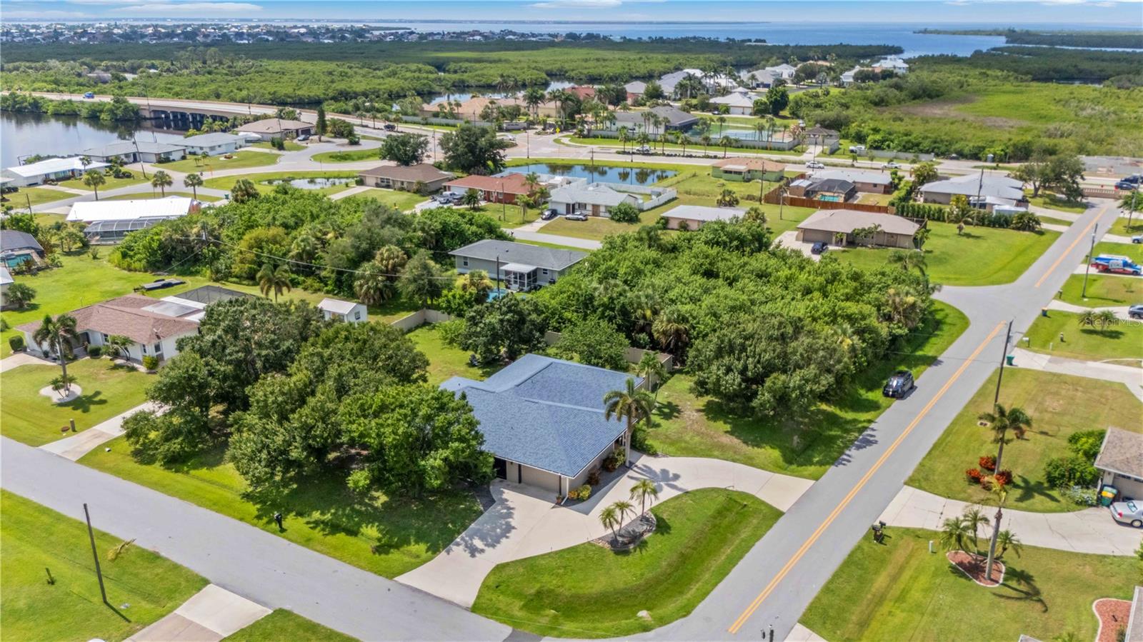 Welcome to your piece of paradise! This move in ready home has great curb appeal with mature landscaping/tress and is located on a fenced in double lot offering you plenty of yard space and privacy! The circular driveway provides additional parking and the home is located just a short drive away from top destinations such as Fishermen’s Village, Sunseeker's Resort, and Downtown Punta Gorda with endless shopping, dining, and entertainment. Upon walking through your front porch and entertaining the home you will be captivated by the open layout, tall ceilings, and stunning wood burning stone fireplace! The living room is spacious for entertaining guests and offers access to the screened in lanai. The oversized kitchen has more than enough cabinet space and has granite countertops along with nice appliances. This side of the home provides an interior laundry room, 3 large guest bedrooms, and the guest bathroom which also has a shower/tub combo and private door to the lanai. The master suite is ideally located on the opposite side of the home and is large enough to accommodate a king bedroom set, desk, additional seating, and more. The master suite also has a large garden tub, his & her sinks, a tiled shower, and a large walk in closet. The garage offers built in storage space and there is an additional sink area for those that fish and boat which will come in handy being only a few minutes away from the Port Charlotte Beach Complex. The property also has a central vacuum hook up in the garage, an updated Square D Electric Panel, and Hurricane Shutters. Contact your agent for a private showing before this one is gone!