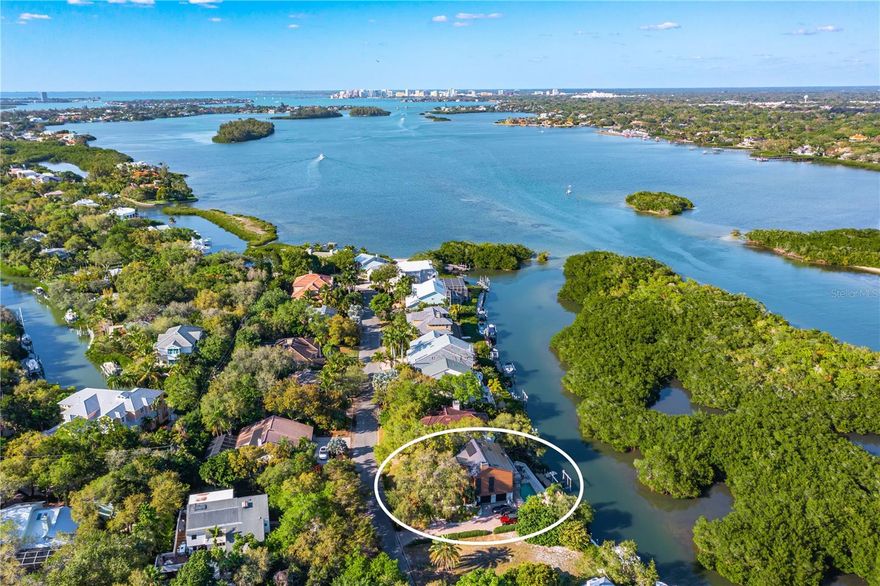 Under contract-accepting backup offers. No Hurricane or Flood Damage.  A coastal modern oasis in Siesta Cove, Siesta Key’s premier neighborhood, highlights 80 feet of waterfront with convenient boat access to Gulf and Bay, with newer seawall, boat dockage, and an extraordinary pool that invites you to enjoy Siesta Key’s relaxed lifestyle. Breathtaking Sarasota Bay vistas along the many peaceful panoramic patio terraces provide endless views of nature. On the main floor, a generous kitchen with gas cooktop island opens into the zen fireplace family room and spacious dining room with soaring ceilings and teeming with nature-filled impact windows. Quartz countertops, sleek wood cabinets, and stainless steel appliances for chefs join the jaw-dropping wall of extensive kitchen windows. Additionally, a powder room and spacious guest bedroom complete with en suite bathroom are located on the main level.  Enjoy the top level primary suite, with loft office, secondary laundry room, third large bedroom and en suite bathroom. The lower level features a family room, fourth bedroom, additional laundry room, and a 2 car garage. This modern coastal retreat boasts energy efficient solar panels and is just a short bike ride away from world class Siesta Beach and the Village. Paradise awaits.