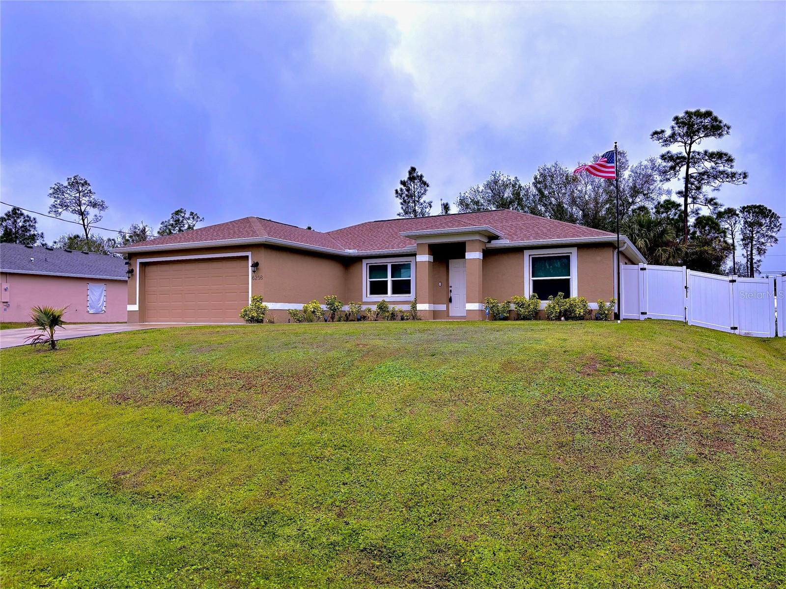 STUNNING 3 BEDROOM MODERN HOME in North Port, FL. Step into luxury with this immaculate 3-bedroom, 2-bathroom home that is not in a flood zone. Built in 2023, this like-new residence offers 1,427 sq. ft. of thoughtfully designed living space on a generous 10,000 sq. ft. lot. Perfect as a primary residence, vacation home, or investment property, it combines modern upgrades with convenience and style. Inside, ceramic tile floors flow seamlessly throughout the home, while vaulted ceilings add spaciousness. The open kitchen features granite countertops and windowsills, stainless steel appliances, and premium plumbing and electrical fixtures. The split floor plan ensures privacy, making this home ideal for families or guests. Designed for durability and comfort, this home boasts hurricane impact windows, a hip roof with asphalt shingles, and central air conditioning. Relax in the fully screened lanai overlooking a beautifully landscaped yard equipped with a three-zone sprinkler system for easy maintenance, or enjoy an evening around the fire pit. The two-car garage provides ample storage, and the location can’t be beat. You’re moments from I-75 and Highway 41, offering quick access to shopping, dining, golf courses, baseball spring training facilities, world-class fishing, boating, and pristine Gulf Coast beaches. Rarely used as a second home, this property feels brand-new and is ready for you to make it yours. Schedule your private showing today. Stop dreaming and start living where others vacation!