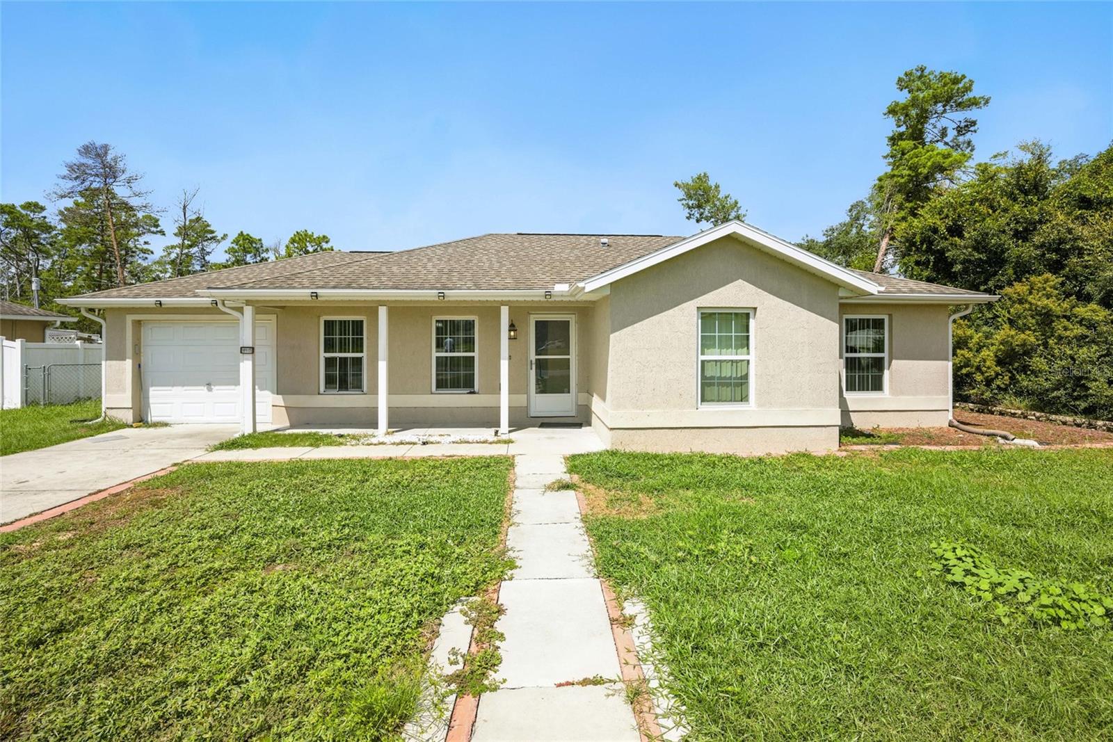One or more photo(s) has been virtually staged. 3-bedroom, 1,089 sq ft concrete block stucco home built in 2017, ideally located near Marion Oaks Blvd! All bedrooms are conveniently situated on the same side of the home, offering functional living flow. Interior features include a mix of carpet and tile flooring, a spacious kitchen/dining area, and plenty of natural light. Step outside to a fully chain-link fenced yard, perfect for pets, play. or gardening. Home operates on public water with a septic system for added utility savings. Great for first-time buyers, investors, or anyone seeking value in the heart of Marion Oaks!
