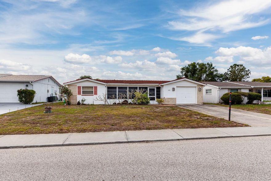 Discover the extraordinary potential within this original two-bedroom, three-bath model residence in the inviting Colonial Hills neighborhood of New Port Richey. As you step inside, be captivated by the expansive enclosed front porch, a distinctive feature of this property. An open canvas awaits your personalization, encouraging you to craft the home of your dreams. The residence comprises a living room, dining room and family room, all seamlessly connected to a spacious Florida room and a second rear porch with views of the generous backyard. The generously sized primary bedroom serves as a private retreat, boasting an en-suite bath and walk-in closet. The well-appointed kitchen, overlooking the family room, eagerly awaits your creative touches. With a tile roof and an oversized one-car garage, this residence combines style and functionality. Embrace the unique opportunity to join this welcoming neighborhood and make this property your own. Don't miss out on this chance and welcome home to a world of limitless possibilities!
