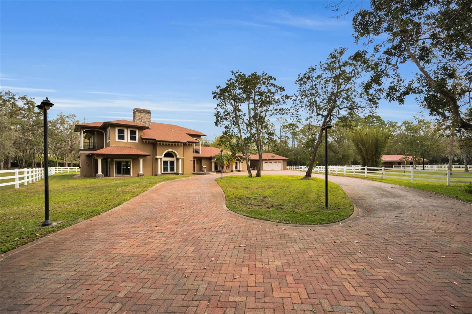 An absolute dream in Oak Hill Acres! Sprawling across 4.4 acres of lush privacy, this equestrian estate offers pure luxury! Located on a fully enclosed and double gated entry corner lot, this stunners offers 4 bedrooms (including 2 master suite options: a master suite downstairs AND a master suite upstairs), 4 full bathrooms, an office, a gym, 2 laundry rooms (1 up and 1 down), saltwater pool & spa, a fully equipped and completely covered outdoor kitchen, a poolside woodburning fireplace, a separate air conditioned safe room space, a gorgeous portico area, a 4 car garage, a beautiful 3 stall barn, a natural pond stocked with bass and an impressive newly built 4 bay RV warehouse! THE GOODS: Roof 2021, A/C’s (3 units) 2019, double pane impact lifetime windows throughout, tankless water heaters (3 units) 2019, new washers/dryers 2019 in both up and downstairs laundry rooms, pool resurfaced 2024, new cartridge pool filter 2024 (sand filter removed), security system 2019, new front gate motor 2019, septic tank pump 2019, 1000 gallon buried propane gas tank, surround sound speaker system both in and out 2019, fresh exterior & interior paint throughout 2019-2020, new flooring throughout 2019-2024, central vac system throughout and dimmer systems on all lighting throughout! THE DETAILS: KITCHEN: The all new chef’s dream kitchen renovation 2019 includes an amazing Dacor gas stove, DCS double oven, impressive SUB ZERO refrigerator/freezer, 2 Bosch dishwashers, wine fridge and ice maker! OUTDOOR KITCHEN: 2020 new built outdoor cover structure/roof 60k. PRIMO 7 burner grill, fridge, sink, icemaker, built in blender, 2 gas burner BBQ, and built in glass gas fire table. BARN: 2018 built 60k, 3 stalls- each with an individual turn out, tack room for all equipment and supplies, wash stall, hot/cold water and electric. Plus multiple fenced in pastures to roam amongst the property. RV GARAGE/WAREHOUSE: 2022 built 80k, 40 X 50 structure, 6 inch concrete floor pad, 4 sets of 16X16 roll up bay doors -awesome! This estate is an absolute oasis! Complete seclusion, yet everything you may need is within minutes! Plus, no deed restrictions - bring all your Florida toys and zoned agricultural - bring all your animals! A true, rare gem!!!