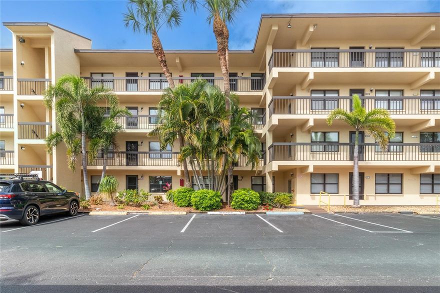 YOU KNEW IF YOU WAITED.....The right unit would come on the market for you to buy in this highly sought after senior gated community.  This Driftwood model is the largest 2/2 unit in Desoto Square. What makes it so special? Besides being the largest unit, it is all updated so no contractor should have to come to this unit. The entire unit has tile flooring for easy cleaning and maintenance. You will love the extra large eat-in kitchen with its breakfast bar which opens onto the lanai. Morning coffee or breakfast will taste better sitting on the lanai and looking at fantastic views of the lake. That routine will surely start your day in a great mood. Looking at water has a calming affect. Along with the updated kitchen, baths and flooring, the sellers just had a new electrical panel installed this year saving a new owner thousands of dollars along with a new AC and H/W tank in 2025. It doesn't get much better than this. But it does, the sellers have installed hook-ups for your own personal washer/dryer in the unit so you won't have to use the common laundry.  The icing on this gorgeous cake...A COVERED parking space. A rarity in Desoto and this one is 15 steps to the elevator. The community itself is gated for peace of mind and has a large heated pool, tennis courts, clubhouse house with lots of activities, pickleball, shuffleboard, exercise room, grilling area, fire pit, walking paths around the lake and a gazebo sitting in the water with comfortable seating for you to relax. The price is considerably lower than it should be with these attributes. All that's left to do is to come see it. View the videos and enjoy what you see.