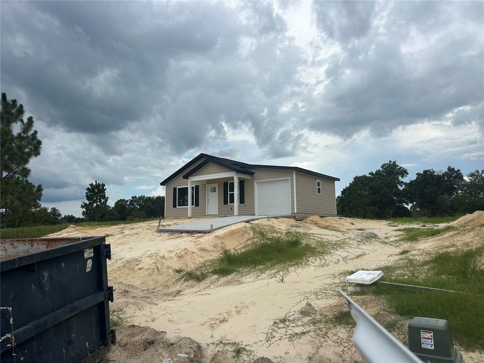 Under Construction. Welcome to this exciting new construction project, a charming and affordable cottage home in the desirable Rainbow Park neighborhood, just a quick drive to the scenic Rainbow River. This home offers an excellent opportunity to experience comfortable living with its well-designed features. Key Features: Spacious Rooms: Enjoy the luxury of generously sized rooms, providing plenty of space for relaxation and everyday activities. Open Kitchen: The home features an open kitchen layout, creating a seamless flow between the kitchen and living areas, perfect for entertaining and family gatherings. Elegant Kitchen Upgrades: The kitchen will showcase granite countertops, adding a touch of elegance to your culinary space. Stainless steel appliances provide modern convenience and functionality. Stylish Flooring: The choice of vinyl plank flooring enhances the home's aesthetic appeal while offering easy maintenance and durability. Country Porch: Picture yourself unwinding on the charming country porch located at the front of the home. It's an ideal spot to enjoy the neighborhood atmosphere and relax outdoors. Unique Roof Design: This home stands out with its 6' 12" pitch roof, adding character and curb appeal, making it one of the most adorable houses in the neighborhood. Three Bedrooms, Two Bathrooms: With three bedrooms and two bathrooms, this home offers a comfortable living space, providing ample room for residents and guests. 1-Car Garage: The inclusion of a 1-car garage provides convenient parking for your vehicle and additional storage space. Cleared Land: The property's land is already cleared, laying the foundation for a smooth and timely construction process. Please note that the home is currently under construction. While pictures and virtual tours are available to offer an accurate depiction of the completed home, there might be slight variations in interior colors. Given its appealing features and prime location near Lake Weir, this home is expected to sell quickly. Don't miss out on the opportunity to own a lovely cottage home in Rainbow Park—an alternative to tiny home living without compromising on the number of bedrooms. Color will be Tan.