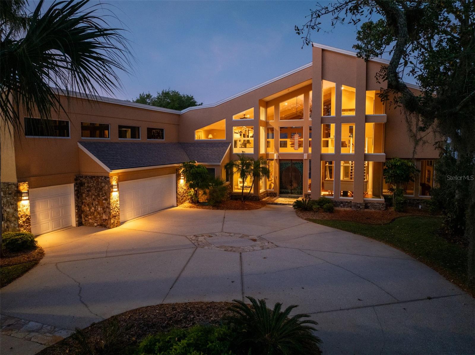 Direct riverfront contemporary estate home like no other offered here on beloved Oak Forest Drive. The stunning, one-of-a-kind architectural design was created to allow for spectacular views from nearly every angle of the open, airy living spaces situated beneath 30' ceilings. With over 7400 sq ft of custom construction, the home features open living areas that are only defined by subtle architectural details. Ideal for entertaining or casual, luxury living the interior was professionally redesigned and subsequently reconstructed by the highly regarded general contractors at Coleman, Goodemote Construction. The spectacular finished product presented here must be seen in person to be truly appreciated. Step inside to immediately be greeted by panoramic water views through large window panels symmetrically arranged to create a wall of glass along the waterfront. Morning sun is welcomed into the main living areas where a catwalk stretches above connecting a sprawling loft to the second story primary suite. The riverfront kitchen and accompanying casual dining and sitting areas were designed to function as an area for entertaining while cooking with two grand kitchen islands, an additional service bar and several prep stations beneath handsome, solid wood cabinetry complimented by beautiful granite tops and top of the line appliances. The adjacent gracious formal dining room is tucked beneath the lovely floating staircase with floor to ceiling windows overlooking the ancient oak trees that shade the front yard. Double doors off the main living room give way to a private den that could serve as an executive office or 4th bedroom. The home was designed with a separate waterfront entertainment and living space dedicated to guests but could be the ideal children's wing for a family. This unique ground floor waterfront living area can easily be opened to the main living room or just as easily closed off with plenty of space for the pool table, wet bar, wine bar and coffee bar...all opening onto the grand waterfront lanai. Just beyond you will find two private and spacious guest suites with vaulted ceilings across the hall from the downstairs utility and laundry room. Upstairs, the owners' quarters with private balcony features unobstructed water views with private sitting room, luxurious bath, cavernous closet/dressing room and dedicated laundry. The fabulous, covered lanai spans the entire length of the home beneath tall ceilings and serves as the owners' open-air waterfront living and dining room. Courtyard entry, oversized three car garage. Just 3.8 miles to the beach, Oak Forest Drive is a quiet oak covered lane where waterfront homes are arranged along the westerly bank of The Intracoastal Waterway at the foot of the vast Tomoka State Park and the scenic highway known as The Loop. This property is a true standout in today's waterfront market and has been priced at a fraction of replacement cost.