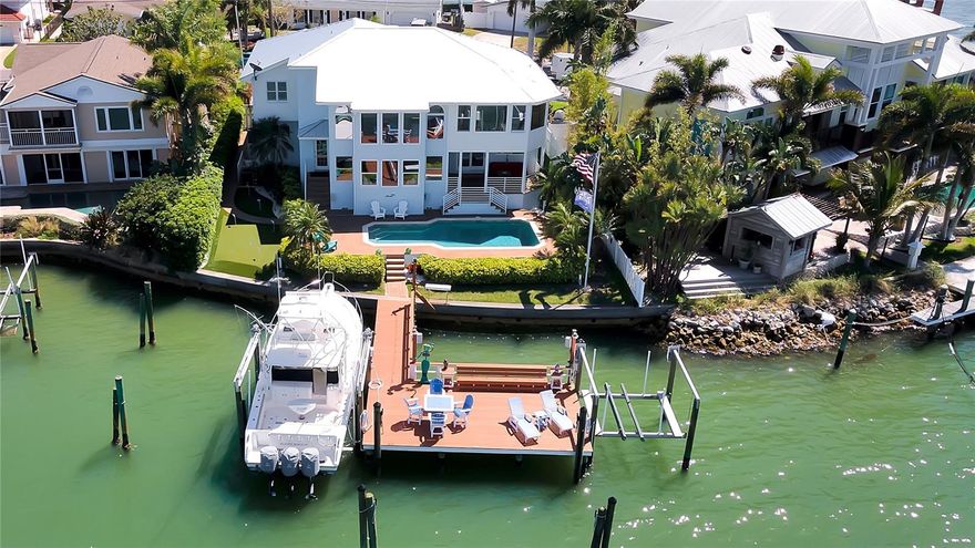 Positioned at the end of a quiet cul-de-sac on EXCEPTIONAL BOATING WATER, this luxurious coastal estate delivers stunning open water views of the intracostal waterway and Belleair Bridge. Lush, tropical landscaping welcomes you to a stunning home which has been fully renovated with custom finishes throughout the grand open spaces. The soaring entry foyer opens to a great room with two stories of windows providing panoramic views of the sweeping waterfront. The professional chef's kitchen must be seen to appreciate its grandeur. It features Bianco Cielo quartz countertops, a 9-foot island with seating for four, a Thermador Dual Fuel 48” Pro-Grand Chef's Range, a 42” Sub Zero Refrigerator, and top of the line KitchenAid Appliances which includes a premium dual zone wine and beverage fridge, under counter ice maker, convection microwave drawer, warming drawer and triple motor Vent-A-Hood. The breakfast bar features genuine ship’s lighting from abroad and the custom dining booth has unique, coastal pendant lights. On the main level you will also find a home theater with top of the line A/V equipment, acoustic engineering and a 4K Projector with its own mini split AC. The sweeping staircase will take you up to four bedrooms, two of which share a large, Jack and Jill bathroom. The master retreat has a catwalk leading to its double door entry. As you enter, you are taken back by the breathtaking, extensive open water, 3rd story elevated views. The master bath is spacious as is the walk in closet. Out back the remarkable finishes continue. Sliders in the kitchen lead to a cozy covered patio. Another set of sliders from the family room also lead out. A door from the pool bath steps down to the pavered pool deck. The PebbleTech salt water pool is heated and cooled and with a new Therm-A-Cool unit and energy efficient variable speed pump. To the right of the pool deck is a newly installed 5-hole chipping and putting green. To the left is a “Pet Platinum”, “Bio-Cell” pet and kid friendly dog run. Your impressive dock setup is a boater’s dream on DEEP WATER! It features premium, “Wear Deck”. Two boat lifts, 24k and 7k, provide space for two 50 ft+ boats. Water has been run to each lift, and there is dedicated 50 amp shore power. At almost 700 sf, the dock is also perfect for entertaining with plenty of room for dining and sunning in the chaise lounges. Dock lighting and speakers complete the 3 levels of outdoor acoustics. Once you push off from your dock, you can be to the Gulf of Mexico in just 5 minutes. All this and you are just minutes from award-winning beaches. This summer, enjoy gorgeous sunsets from your new waterfront oasis.