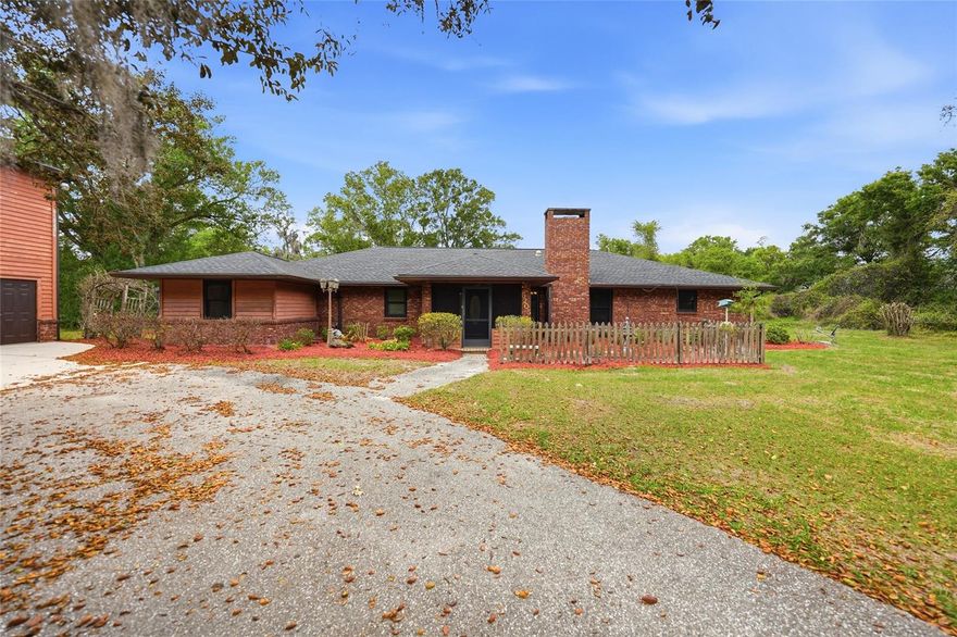 Classic brick, tucked behind a privacy hedge, with the kind of curb appeal that makes you slow down when you drive by. Two car garage, beautiful setting, and then… wait for it… a fully finished apartment above the garage. Yes, really. Inside the main home, you’ve got soaring vaulted ceilings, two skylights pouring in natural light, and a stone wood-burning fireplace that anchors the whole living space. The kitchen is a functional galley layout with a cozy breakfast nook that feels like the perfect spot to start your mornings. Now let’s talk about this primary suite… because it is BIG. Like 15x28 big. Plenty of room to create your own little retreat, plus a massive walk-in closet and an oversized bathroom with a soaking tub that was made for slow evenings. There’s also a huge bonus room that could easily serve as a third bedroom, game room, office… whatever fits your life. And the laundry/utility room? Packed with cabinetry and storage. Everything has its place here. Step outside and it only gets better. Multiple sets of French doors lead you out to a screened-in lanai with an in-ground heated pool, giving you a true indoor-outdoor lifestyle setup. And then the guest apartment… such a game changer. Full kitchen, full bathroom, walk-in closet, and tucked away above the detached garage. Perfect for guests, extended family, or even a little income opportunity. And did I mention that both roofs were replaced 2023? All of this sits on over 6 acres, zoned for animals, with scattered shade trees that just make the whole property feel peaceful and established. There are multiple sheds and outbuildings, plenty of room to spread out, and yes… this is absolutely the kind of place where a tire swing or picnic table just makes sense. This isn’t just a house, it’s one of those properties you have to experience to fully appreciate. And once you do… you’ll get it.
