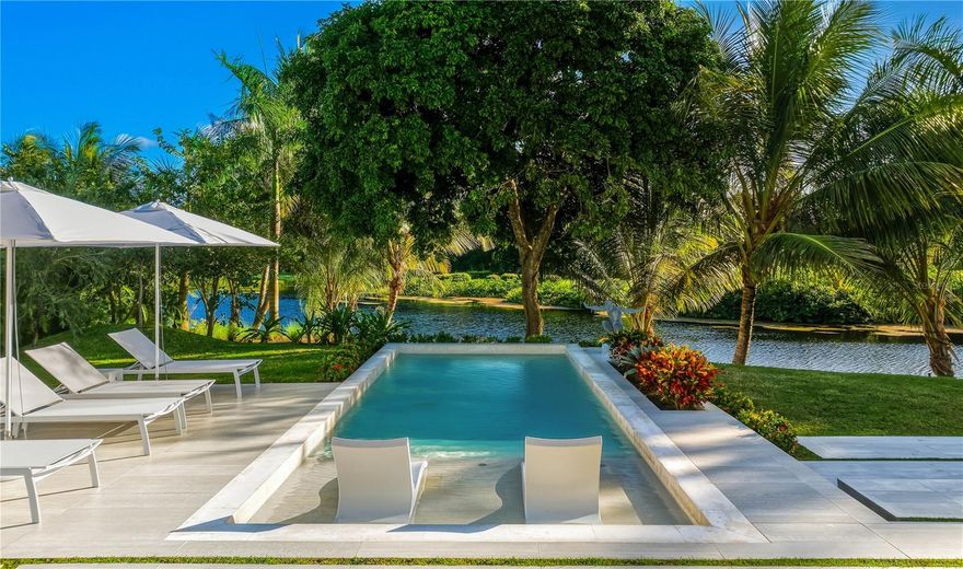 No expense spared on this true to form Caribbean contemporary new construction, sitting blissfully at the eastern entrance to the rainforest and within the esteemed enclave of the branded Four Seasons Resort and Residences Puerto Rico in Rio Grande. Completed in 2024, 23 Las Estancias stands a testament in true adoration to architectural intention and sophisticated purposeful interior design. Sitting on just over 1/2 acre, each curated detail resonates throughout this 3 bedroom, 3 full bath and 2 partial bathroom single level estate. 20+ Ft entry ceilings pull all of the natural light from the floor to ceiling glass doors, with  broad facing western exposure to the lake, mountains and lush tropical backdrop that only the El Yunque rainforest can afford. Brushed blond wood palettes delicately accent the pinnacle of each room's ceilings, pulling in natural textures to the all concrete structure. Limestone floors add a cool tonality to the juxtaposition of ultra green foliage enveloping the home's elevated exterior facade landscaping. Cascading honed marble countertops highlight this double sized gourmet kitchen, featuring a gratuitous 19x19 footprint, and cornered by 10+ ft glass doors that open fully to the property’s magical oasis. Privacy and purpose reign here, where your outdoor summer kitchen equipped with full gas range, sink and bar moves fluidity towards your zero edge swimming pool, which is adjacent to your outdoor shower and bath, dining, sunning areas and hidden entertaining spaces. Guest suites, each highlighting the exotic nature of living within the resort, feature walk-in closets, ensuite baths and full length picture windows encasing the spaces with fresh sunkissed natural light. The primary wing serves as an homage to refined peace. Double entry doors swing inwards towards the 4 post california king bed, masterfully angled towards the estate’s western outdoor living, where hints of running water from the lake abutting the property’s line, and coconut bearing palms sway off in the distance, to this coast's constant melodic breezes. A basin tub swathed in the greenery exposed by the large bay windows, and indoor/outdoor shower textured in raw stone elements, and an 11' 11” X 13' 11” temperature controlled boudoir and closet round out the home's impeccable design. Warm neutrals kiss every element of design here, where Lutron lighting and shades throughout, a fully off grid solar installation on roof and numerous other refined details, allow the owner the ease of purposeful living. 23 Las Estancias serves as a culmination of vision and passion elegantly aligned in both presence and form. The only of its kind, a true 1 of 1.