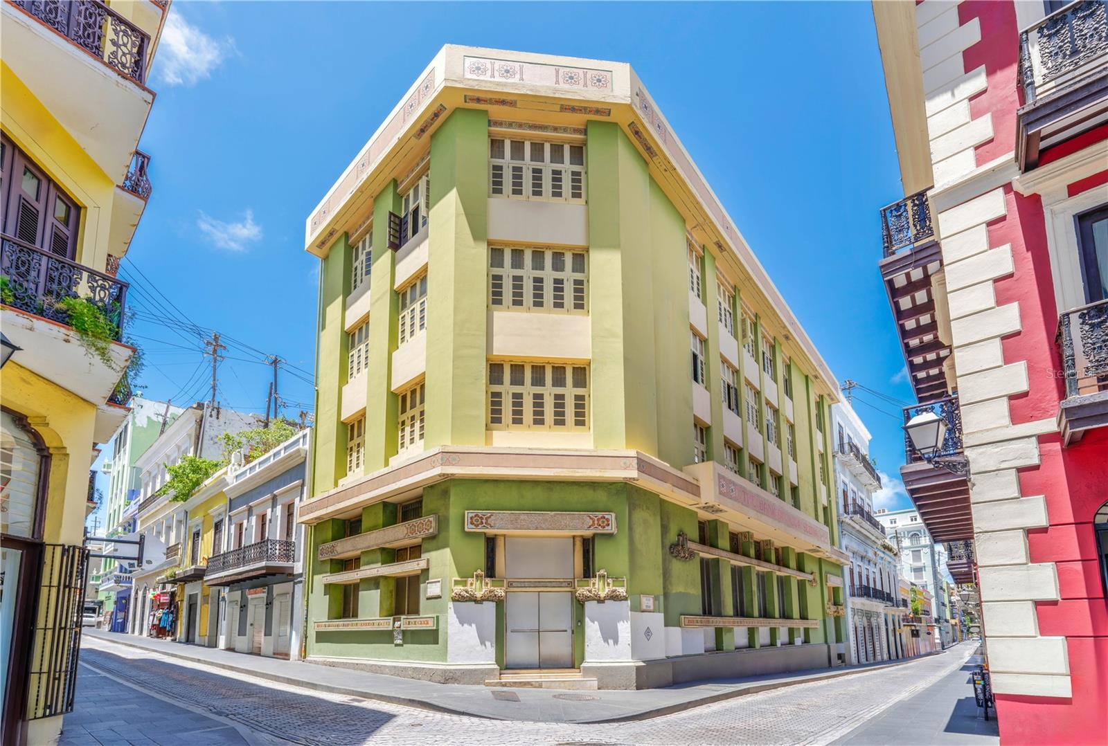 A rare opportunity to own a piece of Puerto Rico’s architectural history awaits at 251 and 253 Tetuan Street in Old San Juan. Designed by renowned Czech architect Antonin Nechodoma and built in 1920, this expansive property was formerly the historic Scotia Bank. The iconic building is offered in a cleaned shell condition, providing a blank canvas for visionary investors to reimagine it as an unparalleled masterpiece with mixed zoning. Spanning five floors with soaring ceilings and a distinctive bank vault in the basement, the building lends itself perfectly to a variety of concepts, including a multi-family or hospitality project. The scale and historic character of the property make it an ideal anchor space in the heart of one of the Caribbean’s most visited destinations. Strategically located at the corner of Tetuan Street and San Justo Street, this prominent building enjoys exceptional visibility and steady pedestrian traffic, just moments away from the bustling cruise port. Once the island’s thriving financial hub, Tetuan Street was home to Puerto Rico’s major banks and remains lined with iconic architecture. Today, it has transformed into a vibrant corridor filled with tourists, shops, and cultural landmarks. This prime corner location places your venture at the intersection of history and opportunity in one of the most dynamic areas in Puerto Rico.