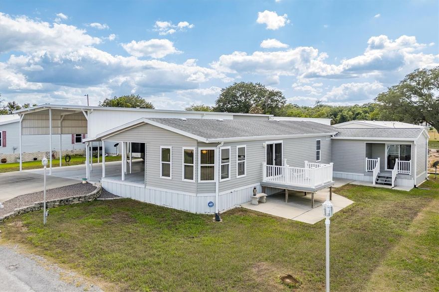 Immaculate 1800 sf RV Port Home with awesome location in the Dade City, FL community of Palm Manor.  This one is a gem.  Open floorplan with 2 bedrooms, 2 baths, but 2 flex space rooms gives it options for more.  Lots of windows and light. Several porches and decks to relax.  The 32 X 40 ft RV Port parking with 14 ft bay side ceiling heights ,   offers so much space under cover,  that you can park a large RV, and multiple vehicles,  or use it for family or friend gatherings.  There is a 50 amp electrical and sewer hookups for the RV.   Also attached is a large workshop with additional loft storage and shelving, and a pulley lift to carry items up to the loft.  The one car attached enclosed garage is available, but current owner uses as a workout room,  hobby room, and additional storage and it comes with a 2nd refrigerator.   The last room is a tool shed with tools and lawnmower provided.  Off of living room is nice 10 ft X 8 foot deck,  with also a covered office/flex room porch at 9 X 5.   The kitchen features an oven with convection feature, a sink Reverse Osmosis system, and a refrigerator with ice maker.   Community amenities include a pool, clubhouse, and recreational courts with bacci ball, shuffleboard, golf driving net,  and pickleball. The community provides a calendar newsletter with fun activities like Bingo, Bowling, Chair exercises, game night, pool aerobics, crafts, and other events.  The parklike setting makes it feel like you are on vacation at all times.  This home is approximately 30 minutes to Lakeland,  one hour from most theme parks, and about 45 minutes to Tampa and the International Airport.  The other bonus about this location is that it is approximately 2 hours from each coast, and lovely Florida beaches.   This is a one owner home,  and is move in ready.