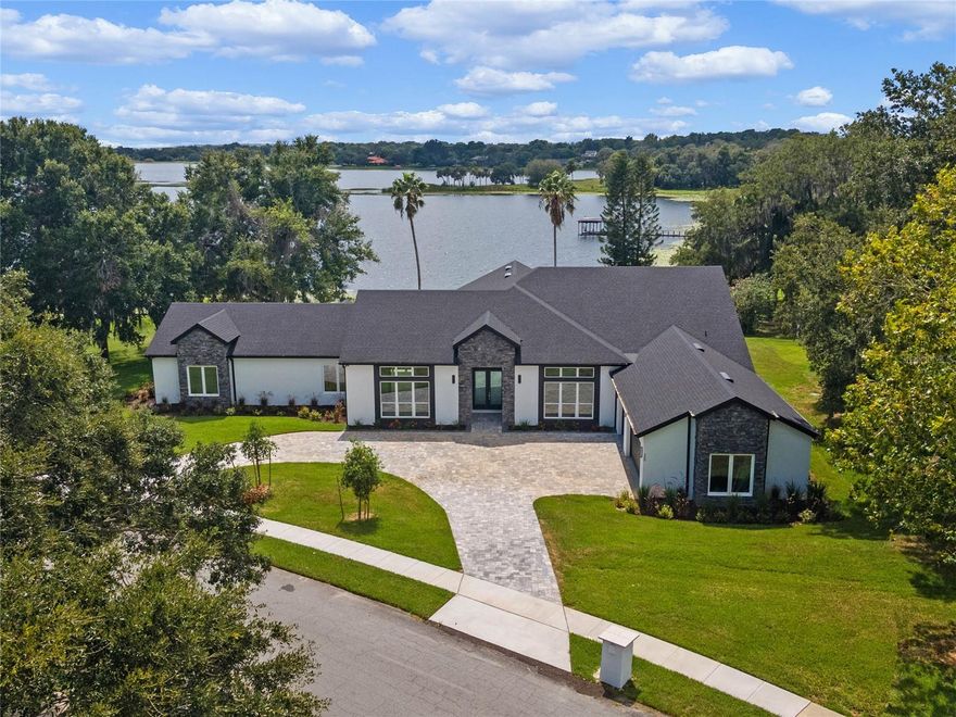 This BRAND NEW CONSTRUCTION home directly on John's Lake is one of a kind with over 2 acres behind, high and dry, over 500 feet of direct lake frontage, plus 4700 sqft of living space, 5 spacious bedrooms, 4 full bathrooms, one half bath and a true open concept design. As you walk in the front door,  you're greeted by tons of natural light from all the sliding glass doors and oversized windows, along with 12 foot high ceilings, a living room, dining room and kitchen combo, plus luxury hardwood flooring throughout the entire house. The family room is perfect for all gatherings, cozy nights in, and has breathtaking views of the lake. The kitchen has a massive island, luxury countertops with a waterfall feature over the sides, plenty of cabinetry, high end appliances, and perfect for entertaining as it's open to the entire home. If you enjoy having a large formal dining room and living room then this house has designated areas for both! The owner's suite is on the left side of the house and is completely private with tons of amenities. The owner's suite has stunning views from the bedroom, ensuite, closets and even the workout room. The owner's ensuite has his and her vanities, custom lighting, a large walk in shower with high end tile work, a soaking tub that sits in front of a large window overlooking the lake, and is completely private with exterior walls on the side. The owner's retreat also offers two oversized closets, and a third room that could be another closet, a nursery, a second office, or even a home gym. The right side of the home offers 3 spacious bedrooms all with ensuite bathrooms and walk in closets. It also has a half bathroom for guests and a laundry room with built in cabinetry and sink. If you enjoy entertaining then open up your sliding glass doors and step onto your over 500 sqft of covered lanai space with wood ceilings and sunset views. This property has a grandfathered in tree house boat dock that can be one of a kind for this neighborhood. This property has the ability to add an additional mother in law suite, casita, secondary garage or etc. John's lake is approximately 2500 acres that offers sport fishing, skiing, canoeing, kayaking and all other water-sports. This new construction home comes with a builder warranty as well, ask for further details! This home is nestled in the highly sought after Deer Island community, known for its lake frontage on John's lake, community amenities and amazing location right between downtown Winter Garden and Downtown Clermont. It's also located just a short drive from the magic of Disney, the vibrant atmosphere of International Drive, and premier shopping at Millennia Mall, this home offers convenience paired with quality. Montverde Academy, a world-class educational institution known for its commitment to academic excellence, is also less than seven miles away. Discover the perfect blend of sophistication and functionality in this meticulously crafted home, offering both comfort and style. Schedule a private viewing today and make this your retreat in the heart of convenience.