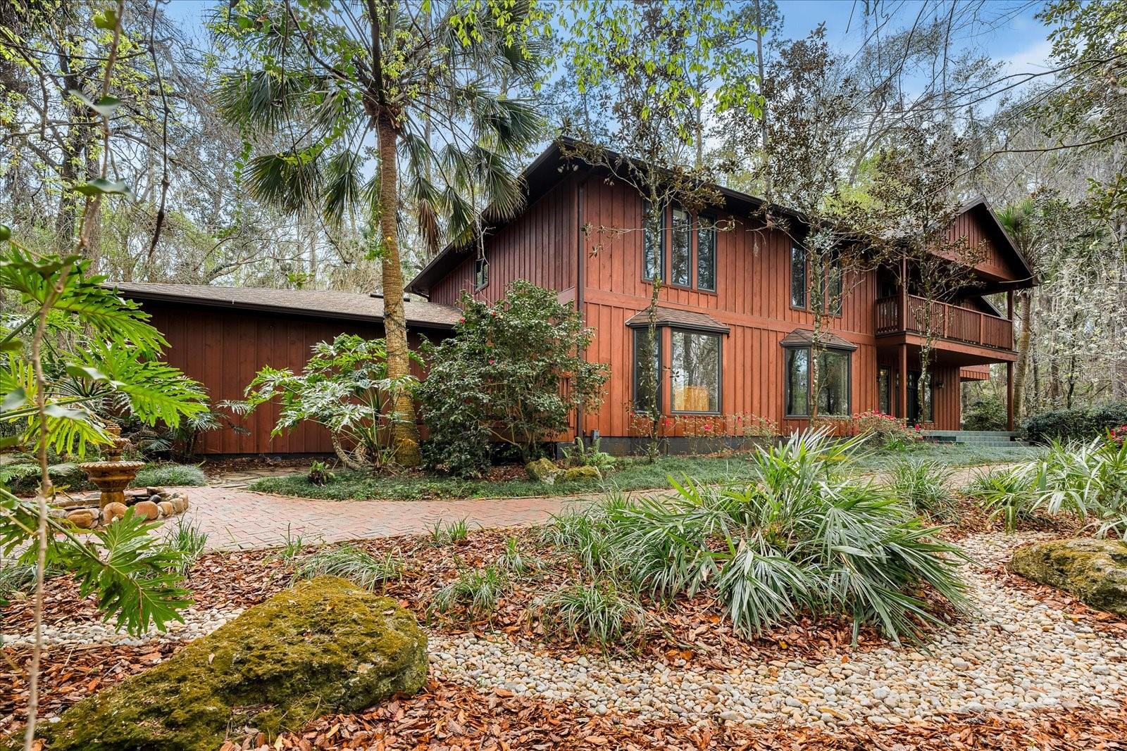 Beautiful, spacious 6-7 bedroom pool home with exceptional privacy less than a mile from the University of Florida. Nestled in one of Gainesville’s best-kept residential secrets—Shands Woods—this custom-built John Van Mills home sits on over 2.5 acres. Sitting high above protected wetlands along the Hogtown Creek. This home blends natural beauty, timeless design, and modern upgrades, and is a true hidden gem in the heart of Gainesville.
Inside, the home welcomes you with a breathtaking two-story family room featuring cedar batten and board walls and a striking wood-burning Spade stone fireplace, evoking the warmth of a mountain lodge. The home offers elevated views of the surrounding preserve and creek while maintaining complete privacy. The first floor includes a formal living room with bay windows overlooking the preserve, a formal dining room with custom built-ins, a spacious kitchen with a center island, double oven, and eat-in area, and a peaceful primary suite. The kitchen and breakfast area open to the pool through French doors, creating a seamless indoor-outdoor flow. The primary suite overlooks the wooded yard and pool and includes a spa-inspired bathroom with a soaking tub, walk-in shower, split vanities, and a one-of-a-kind indoor terrarium.
Upstairs, you’ll find five additional bedrooms, a large office, and a versatile game room that can serve as a seventh bedroom, playroom, or creative space. Two bedrooms feature private en suite baths, while the remaining three share a spacious bathroom with dual vanities and a jetted tub. A private deck overlooking the pool is accessible from both a bedroom and the game room, while other rooms provide serene views of the surrounding preserve. A spiral staircase from the game room leads conveniently down to the laundry room.
Step outside to your own private oasis: a 30,000-gallon pool surrounded by lush landscaping and total seclusion. A private staircase provides direct access to Hogtown Creek. With protected wetlands on the property line, you’ll enjoy lifelong privacy with no future development—and no front-door neighbors.
This home has been meticulously maintained and thoughtfully updated, featuring a new roof (2024), water heaters (2022), fresh interior and exterior paint, and new flooring in most living areas. Located in the highly desirable, no-HOA neighborhood of Shands Woods, this home offers the feel of a private retreat with the convenience of being just minutes from UF, Shands Hospital, the VA, and downtown Gainesville.
If you're searching for space, privacy, and proximity to the University of Florida, this one-of-a-kind Gainesville pool home is a must-see. Schedule your private showing today!