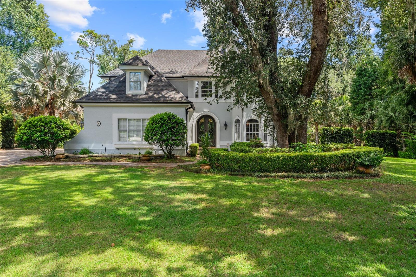 Old Florida charm meets modern luxury in this stunning estate home located in the sought-after Sugar Mill Plantation community, with easy access to beautiful downtown Flagler Beach. Surrounded by lush landscaping and majestic oaks, this residence offers both timeless elegance and contemporary comfort. Step through custom double steel entry doors into a dramatic two-story foyer with travertine floors and a grand chandelier. The formal dining room boasts rich Cypress wood floors, crown molding, custom trim work, and expansive windows overlooking a private side yard. The completely remodeled gourmet kitchen is a chef’s dream, featuring a Sub-Zero cabinet-front refrigerator, Wolf appliances, double oven, Cambria quartz countertops, gas range, two beverage fridges, built-in coffee/espresso system, and pantry closet. A charming breakfast nook with wood ceiling details, French doors, and large windows offers picturesque views and abundant natural light. The family room showcases travertine flooring, vanishing sliders to pool with electric shades, and additional access to the covered lanai through French’s doors. A private office with Cypress wood floors, custom built-ins and bay window for your private workspace. Downstairs completed with custom grand half bath perfect for guests, and picture-perfect laundry room with cabinetry, sink, and outdoor access. Upstairs, the primary suite features vaulted ceilings, Cypress wood floors, French doors to a private tiled balcony overlooking the preserve, custom walk-in closet, and a renovated spa bath with clawfoot tub, dual quartz vanities, linen tower, and walk-in tile shower. Bedroom 2 is set up like a junior suite- a spacious guest suite with bay window, crown molding, ensuite bath with soaking tub and walk-in showers, Plus another oversized bedroom 2 with wood floors, walk-in closet, and serene views. Additional bathroom 3 upstairs with tile tub/shower. All bedrooms upstairs, grand in size and private. The outdoor living space is an entertainer’s paradise with an electric heated pool, travertine decking, outdoor shower, fenced yard, and complete privacy surrounded by mature trees. Anchored on the end of the cul-de-sac with preserve tree lines. Additional highlights include: NEW ROOF 2024, 2-car garage with Shark coating floors, Whole-house water filtration system, under stair wine storage and additional upstairs storage closet, Crestron smart home automation (audio, lighting, blinds, garage, security cameras), Landscape lighting & irrigation system, Whole-house generator plug, 90-gallon hybrid hot water heater (2024), Septic serviced June 2025. With Cypress wood floors, travertine tile, Cambria quartz countertops, and custom crown molding throughout, this home blends refined craftsmanship with modern upgrades. Sugar Mill Plantation is renowned for its tranquil streets lined with sweeping oaks, offering a true Old Florida setting, just minutes from Flagler Beach’s shops, restaurants, and sandy shoreline. Experience timeless Old Florida charm blended with modern luxury in one of Flagler Beach’s most beautiful communities—this home truly has it all.
