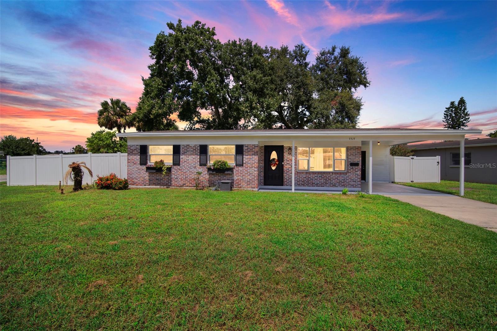 Charming Move-In Ready Home on a Corner Lot – Location, Location, Location! Modern charm meets timeless style—flower boxes, clean lines, and a manicured lawn welcome you home. Striking curb appeal continues with tasteful brick accents, sleek black finishes, FRESH EXTERIOR PAINT, a newly painted carport, TILT IN DOUBLE PANE WINDOWS and a BRAND NEW ROOF, perfectly blending classic charm with modern style. Step inside to a home where every detail feels intentional and inviting. Situated on a corner lot, this move-in-ready, 3-bedroom, 2-bathroom, 1,038-SF gem offers a seamless blend of comfort and thoughtful updates. The open floorplan showcases a Picture Window which brings in an abundance of Natural Light in the living room, wide baseboards, bright white interior paint, and cohesive finishes throughout, from the wood tile flooring to timeless white shaker cabinetry, creating a polished look that flows beautifully from room to room. The kitchen features quartz countertops, stainless steel appliances, bright white shaker cabinets, and a window overlooking the backyard, perfectly balancing function and style. The living room’s large picture window frames the lush front lawn, while the dining area flows seamlessly between the kitchen and living room, creating an open, airy space ideal for entertaining and everyday living. Just beyond, the thoughtfully designed laundry room continues the home’s cohesive style with quartz counters, built-in shaker cabinets, and a utility sink. From the kitchen and dining area, sliding doors provide easy access to the backyard, which features a brick-paved patio, a matching brick firepit, a backyard shed, and expansive lawns front and back—each upgrade intentionally chosen to complement the home’s aesthetic while adding lasting value. The backyard is enclosed with a crisp white vinyl fence, adding both style and privacy. All bedrooms are tucked away down a private hallway. The guest bathroom boasts dual sinks with quartz countertops, white shaker cabinets, and a chic tiled shower/tub combination, while the primary suite offers serene backyard views and a stylish ensuite complete with a quartz vanity and walk-in shower. Guest rooms enjoy their own views of the vibrant front lawn, enhanced by TILT IN DOUBLE PANE WINDOWS throughout that fill the home with natural light. Best of all — this home is not located in a deed-restricted community and has no HOA, giving you freedom and flexibility rarely found in such a prime location. Conveniently near Hillsborough Avenue, Tampa International Airport, the Veterans Expressway, shopping, dining, and beaches, this home embodies convenience, character, and that special touch that makes it truly stand out. Schedule your private showing today!