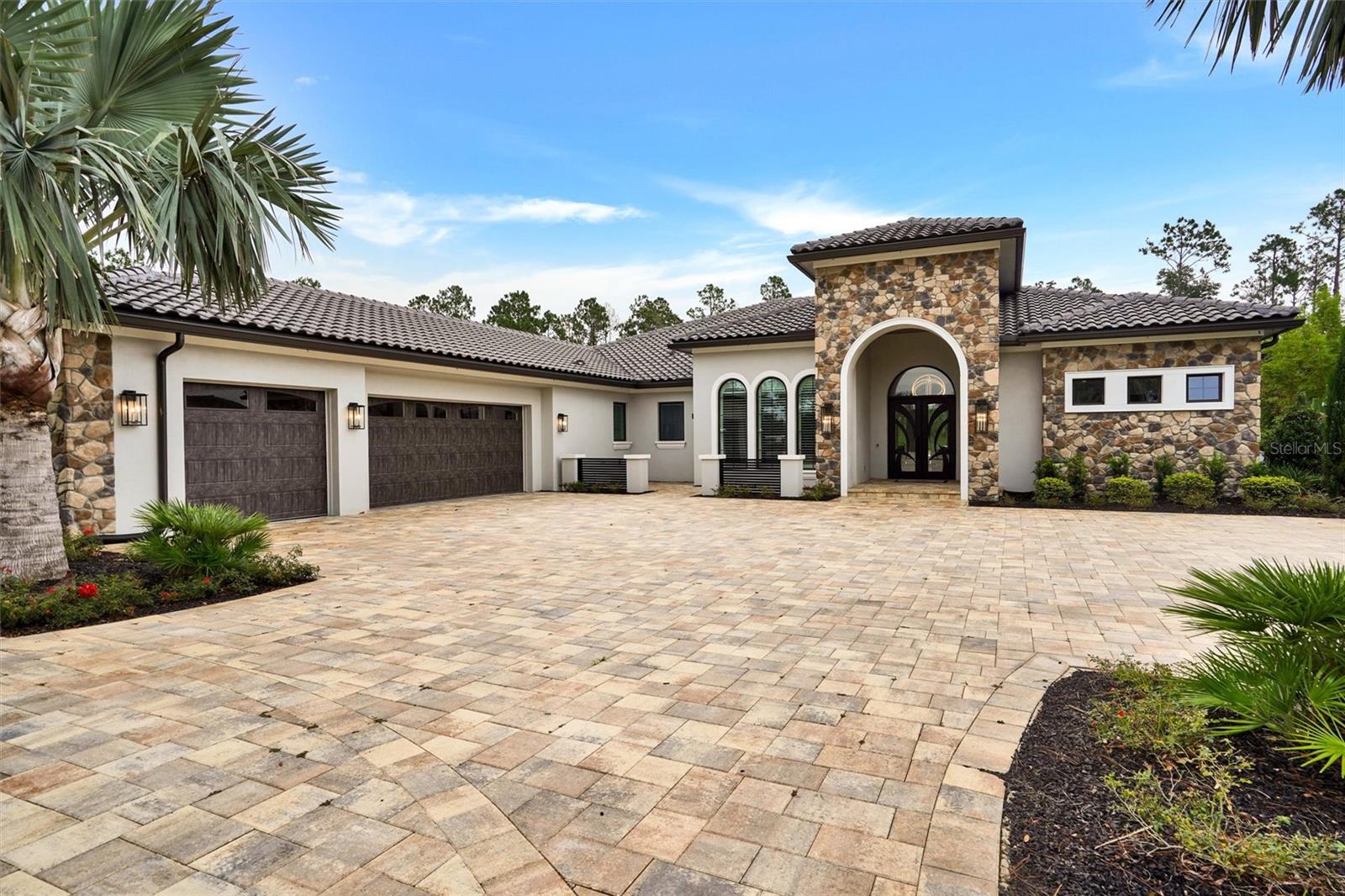 Experience the Pinnacle of Luxury Living in Bella Collina
Welcome to a one-of-a-kind luxury estate nestled on an oversized, meticulously landscaped lot in the luxurious, guard-gated community of Bella Collina—Central Florida’s premier golf and lifestyle destination.
This stunning 5-bedroom, 5-bath modern masterpiece offers the perfect blend of sophistication, comfort, and innovation. From the moment you arrive, you’ll be captivated by the breathtaking curb appeal, highlighted by an expansive paver-stone driveway and a 3-car garage with mini-split A/C for added convenience.
Inside, designer features abound—porcelain floors throughout, motorized shades, and full smart home technology for lighting, climate, audio, video and security.
The expansive great room is the heart of the home, designed for both everyday living and elegant entertaining. It boasts a 100-inch TV, a sleek electric fireplace mounted on a granite accent wall, and soaring ceilings that create a sense of warmth and grandeur.
The chef’s kitchen is a culinary dream, equipped with a Sub-Zero refrigerator/freezer, Wolf 6-burner gas range, GE Monogram double ovens, a Sharp microwave oven, matching granite with the great room and custom cabinetry with premium finishes.
Step outside to the resort-style lanai, thoughtfully divided into three distinct areas:
A relaxation zone with a gas fireplace and 100-inch TV mounted on a stone accent wall.
A versatile dining or gathering area adaptable to your needs.
A summer kitchen with grill, sink, refrigerator, and bar seating.
The over 1500 square foot covered lanai is enclosed with retractable screens that open to reveal the stunning pool with waterfalls, fire features, spa, dry seating conversation pit and a covered cabana complete with ceiling fans and a comfortable lounging area.
Retreat to the luxurious primary suite, which features its own large-screen TV, a beautiful electric fireplace, dual walk in closets and finishes that feel straight out of a high-end resort including built in mini fridge, sink and a spa inspired bathroom with soaker tub, an oversized walk in shower with built-in benches and multiple shower heads.
One of the bedrooms could serve as a secondary primary suite, designed with corner sliding doors that fully retract, offering immediate access to and views of the stunning lanai, pool, and gardens.
Additional features include:
A private in-law suite with exterior entrance, kitchenette, walk-in closet, full bath, and screened-in covered porch.
A dedicated office with custom built-ins
Spacious guest bedrooms and elegantly appointed ensuite bathrooms throughout.
Living in Bella Collina means enjoying world-class amenities including 24-hour gated security, a Nick Faldo–designed championship golf course, luxury spa, tennis, fitness center, and a picturesque Tuscan-style clubhouse.
This is more than just a home—it’s a lifestyle.
This home has far too many exquisite features to list. This home must be viewed in person to be fully appreciated. Schedule your private showing today and see why this extraordinary property stands in a class of its own.