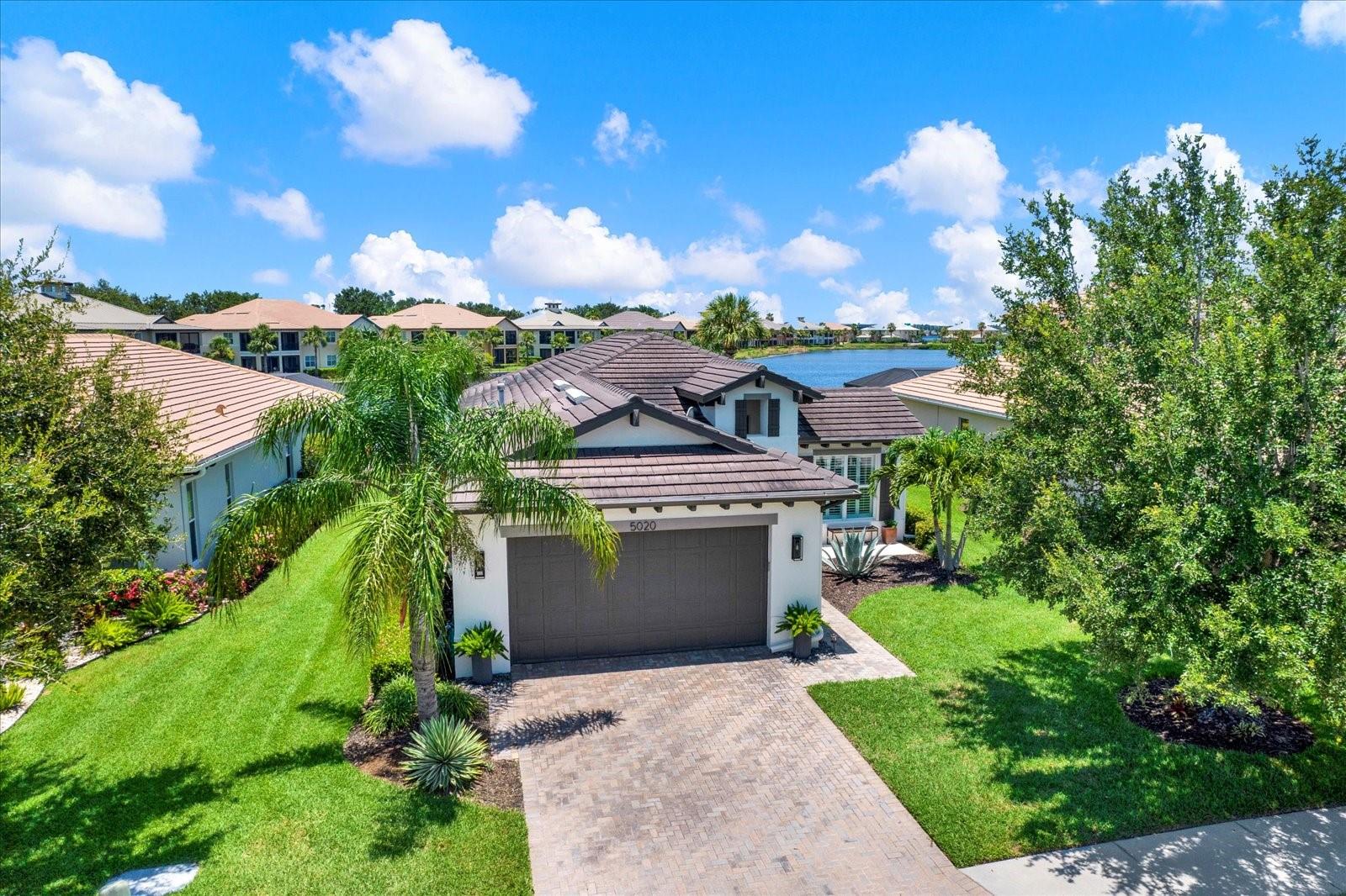 Step inside and experience a home designed for relaxed Florida living. A spacious, light-filled layout welcomes you with defined yet open spaces that flow seamlessly and offers tranquil lagoon views. At the heart of the home, the kitchen features stainless steel appliances, a center island, coffee bar, and a cozy breakfast nook that overlooks the water, perfect for starting the day with a view. A formal dining room or flexible seating area offers additional space for hosting guests and special occasions.
The great room opens seamlessly to the outdoors, where a covered patio invites you to relax and unwind. Entertain outside with a fully equipped outdoor kitchen, expansive pool, and serene lagoon backdrop create the ideal setting for al fresco dining or weekend gatherings.
Inside the well thought out home is a private study or den that is enhanced with custom built-ins, perfect for a home office or library. The spacious primary suite offers a peaceful retreat with a walk-in closet and a luxurious en-suite bathroom featuring a soaker tub, standalone shower, and dual sinks.
Located in Tidewater Preserve, this home is part of a gated, resort-style community offering access to a clubhouse for private events, a fitness center, community pool, boat lift, and an outdoor entertaining space with a fireplace and grills, all set along the picturesque Manatee River.
Just beyond the gates, discover the laid-back coastal lifestyle Bradenton is known for, from boating, fishing, farmers markets, waterfront dining, and nearby Gulf Coast beaches. All this near charming downtown districts, golf courses, and easy access to Sarasota, Lakewood Ranch, and I-75, this home offers the perfect blend of community, comfort, and coastal convenience.