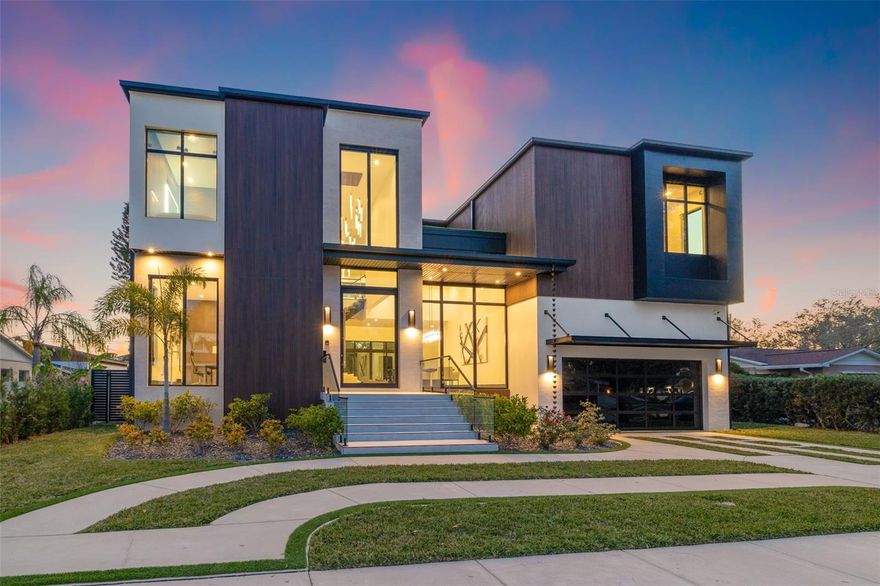 Introducing this recently constructed masterpiece, expertly designed by renowned architect Thomas Lamb, showcasing a modern "block on block" design built atop a 9-course stem wall. Engineered for both style and resilience, this home features large hurricane-resistant windows by Energia Solar Windows, a fully adhered 60M TPO flat roof with gutters, and open cell foam ceiling insulation with Corefill 500 in block for exceptional energy efficiency. Three Trane AC units provide optimal climate control, including a two-zone system upstairs. Technology and luxury converge with a full Control4 smart home system, 18 Stealth Acoustics invisible speakers throughout, a Vantage customizable lighting system, 5 indoor/outdoor wireless access points, and a comprehensive security package including 7 Luma surveillance cameras and a Control4 DS2 Mini Door Station.
The home boasts dramatic architectural elements such as 24’ vaulted ceilings in the living room, 16’ in the dining, and 12’ ceilings throughout the main level with 10’ ceilings upstairs. Italian-imported oversized porcelain tile, a floating steel staircase with hand-stained oak treads, and glass railings add elegance. The luxury elevator features an 8’ cabin, touchscreen controls, and oversized porcelain tile across three stops. The 17’ high two-car garage with a black-framed glass door allows for a lift to accommodate up to four vehicles.
Interior highlights include two BioFlame fireplaces, linear vents, wall-hung toilets, LED mirrors, and floor-to-ceiling tile in all bathrooms. The kitchen is a chef's dream with grain-matched wood veneer cabinetry, gold hardware, built-in JennAir columns and coffee maker, an induction JennAir range, pot filler, Thermador wine column, and a quartz leathered-finish waterfall island. A hidden coffee bar/butler’s pantry is tucked behind custom office shelving. The master suite features a private balcony, seating nook, wet bar with refrigerator/freezer drawers, a custom LED-lit closet with motion sensors, and a spa-inspired bath with a smart tint window, Anthem digital Kohler system, ceiling-mount plumbing, soaking tub, and hidden-drain quartz sinks.
Outdoors, enjoy an entertainer's dream space with an oversized patio, raised glass-tile spa with 8 jets and overspill, pool with 3 fountains, turf lawn, mature landscaping, uplighting, outdoor directional speakers integrated into the Control4 system, aluminum pergola, full Summerset-equipped kitchen with granite countertops, and hightop seating. Additional features include closed aluminum tongue-and-groove patio soffits, an underground irrigation/drainage system, and a standard new construction warranty package: 1-year workmanship, 2-year systems, and 10-year structural coverage under a 2-10 Builder’s Warranty. This residence is the perfect balance of innovation, sophistication, and thoughtful design. Nestled in the highly sought after Snell Isle neighborhood, this home offers more than luxury—it delivers a lifestyle. Snell Isle is a golf cart-friendly community with easy access to the Vinoy Golf Club, downtown St. Pete, the iconic St. Pete Pier, and the city's vibrant arts, fashion, and dining scenes. Whether heading to a gallery, waterfront restaurant, or boutique, everything is just a short ride away. Enjoy the perfect blend of coastal charm and city convenience in one of St. Petersburg’s most desirable locations.