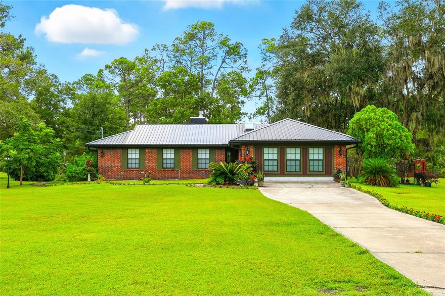 Tucked away in the peaceful countryside of historic Saint Augustine, this one-of-a-kind property combines rural charm with city convenience. Ideally located just 2 miles from the I-95 World Golf Village exit and only 11 miles from the ocean, this home offers a lifestyle that’s hard to find anywhere else in the area.
The well-built brick residence has been fully remodeled into an open-concept floor plan and features a brand-new galvanized metal roof. A stunning Great Room addition, completed in 2024, expands the living space and makes this home truly exceptional.
Step inside to find high-beamed ceilings, elegant chandeliers, rich hardwood floors, and spacious areas perfect for gatherings. The newly designed kitchen showcases luxurious granite countertops, Italian travertine flooring, stainless steel appliances, and a generous walk-in pantry.
The show-stopping Great Room boasts a dramatic 16-foot cathedral ceiling with exposed beams, seven oversized 6x6 ft windows, gleaming hardwood floors, and a striking two-way wood-burning fireplace crafted from natural Tennessee mountain stone. Bathed in natural light, this space offers tranquil views of the property and seamless access to the pool and covered patio.
Opportunity awaits—the covered patio rests on a concrete slab, creating the potential for a future 4th bedroom or in-law suite with private access to both the Great Room and pool area.
Set on 1.99 acres of high and dry land (no flood zone), the property is surrounded by lush landscaping that includes majestic Florida live oaks, citrus trees, and year-round blooming botanicals. Local wildlife such as wild turkey, deer, and a variety of birds can often be spotted roaming the grounds, while the land also supports livestock, as many neighboring farms do.
Three outbuildings add even more value: a small barn with three sections (ideal for livestock and storage) complete with a chicken coop and eight nesting boxes, plus two sheds—including one with a side carport.
With endless possibilities for both living and lifestyle, this property offers a rare blend of elegance, functionality, and natural beauty. Don’t miss your chance to see it in person—schedule your showing today!