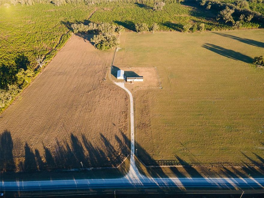 One or more photo(s) has been virtually staged. Have you ever dreamed of enjoying peace, privacy, and room to roam? This rare opportunity offers true homestead living on the border of Newberry and Jonesville—just minutes from all that Gainesville has to offer, yet far enough to experience the serenity of the countryside.
Welcome to Quarry Fields, a small subdivision featuring four 10 acre parcels, located just 2.4 miles off Newberry Road on NW 202nd St. This remarkable property provides unmatched privacy with no neighboring homes behind, beside, or across from you—only quiet, picturesque landscapes. A beautiful wrought iron gate welcomes you at the entrance. Travel down the long driveway to a spacious 2,300+ sq ft residence, accompanied by a detached 3-car carport with garage/storage and an additional 690 sq ft climate-controlled finished space—ideal for a future guest suite, man cave, home office, mother-in-law suite (with the addition of a bathroom), Airbnb potential, and more. Built for peace of mind, the main home is constructed to withstand a Category 3 hurricane. Inside, an open-concept great room with tray ceilings and crown molding flows into the dining area, kitchen, and second living space. The kitchen features a generous island, stainless steel appliances, gas range, walk-in pantry, and ample storage. The split floor plan places the primary suite off the kitchen, offering a large walk-in closet and ensuite bathroom with dual sinks, walk-in shower, and soaking tub. Three additional bedrooms and a full bath are located on the opposite side of the home. Additional features include insulated Low-E windows, LED lighting, wood cabinetry, stainless appliances, and expansive covered front and rear porches—perfect for embracing the peace and views of your private homestead. This property features ideal pasture land, perfect for livestock, horses, or other agricultural pursuits. Fully fenced with a partially fenced area for dogs to roam, this home sits on a 10-acre parcel, and there are also three additional 10-acre parcels available for purchase—offering the potential to expand or for family, investment, or agricultural use. Purchase all 40 acres for a private farm or an opportunity for development into the current four 10 acre subdivision or potentially a subdivision into 5 acre lots. Buyer to verify all information. Schedule your private showing today to explore all this property has to offer.